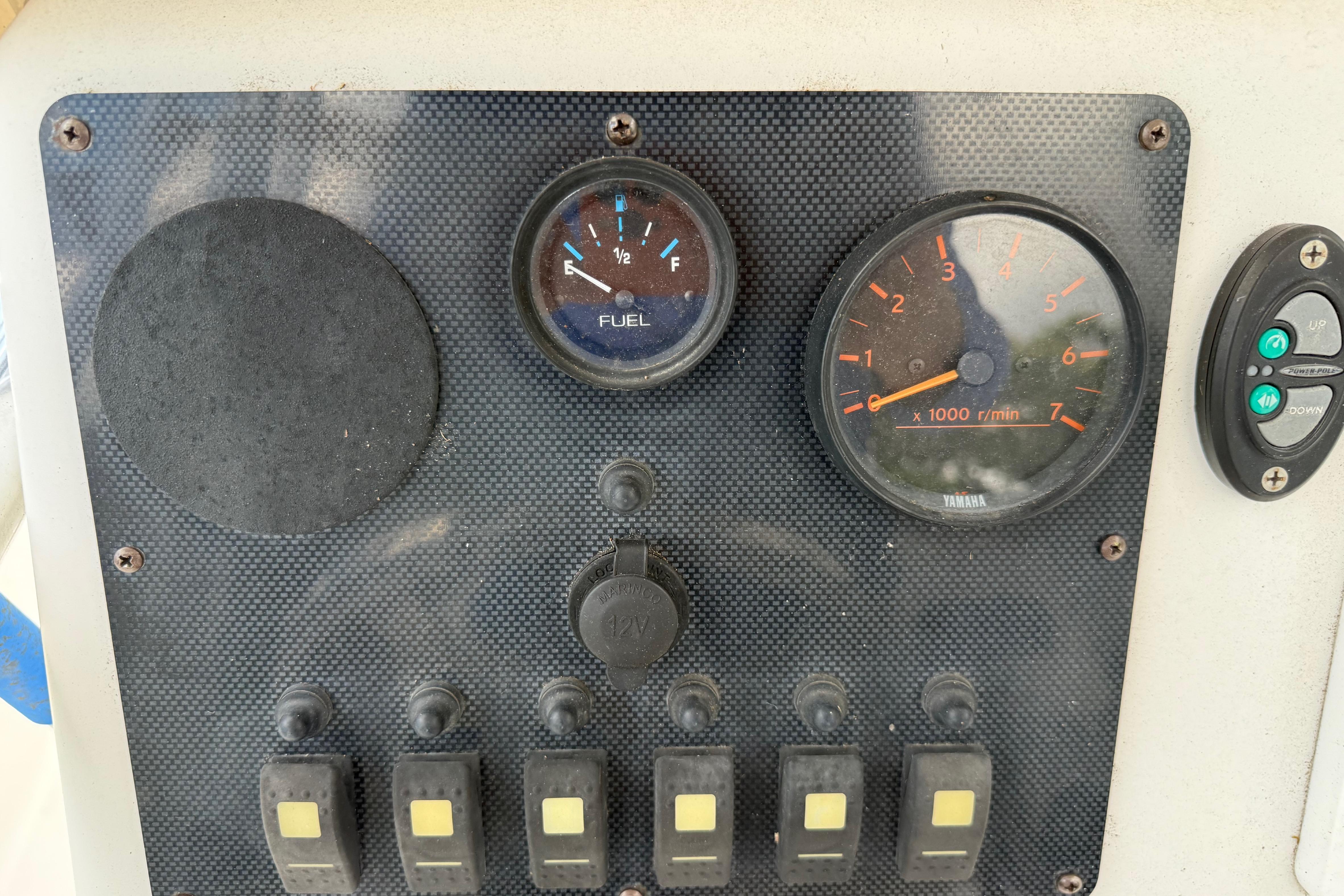 Control panel of a 2012 Clearwater 2000 Center Console boat with gauges and switches.