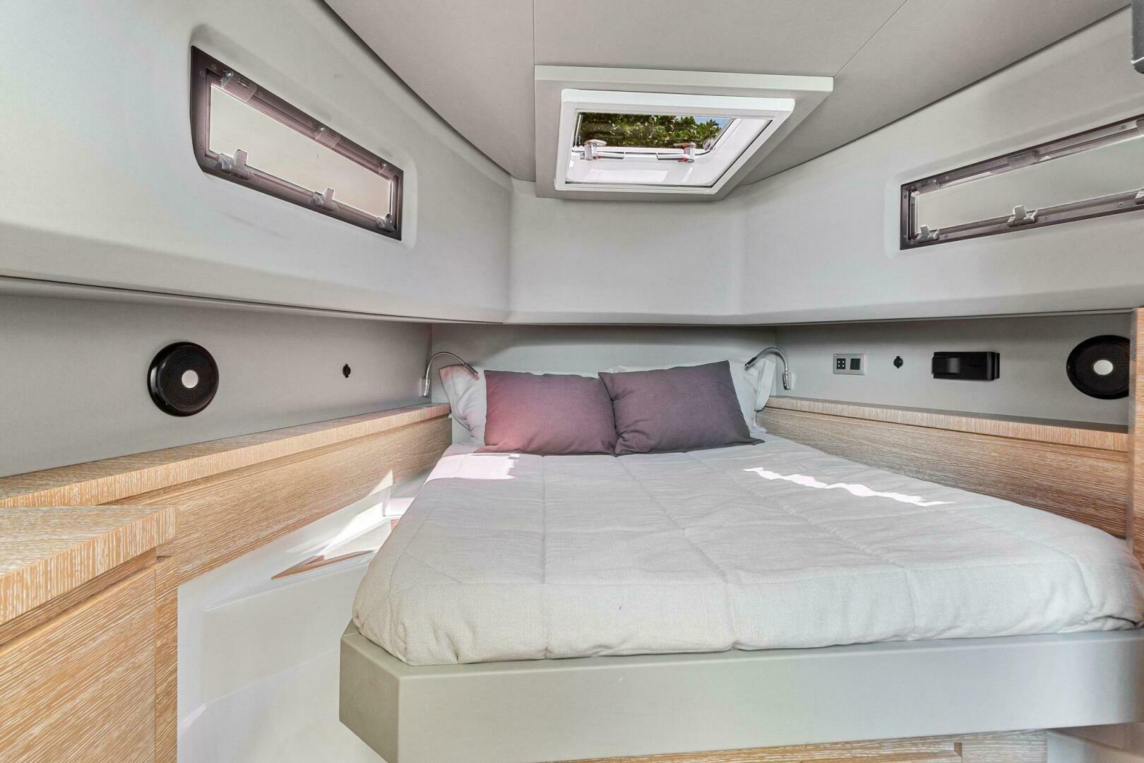 Luxurious cabin interior of 2023 Astondoa 377 yacht with modern design and comfortable bedding.
