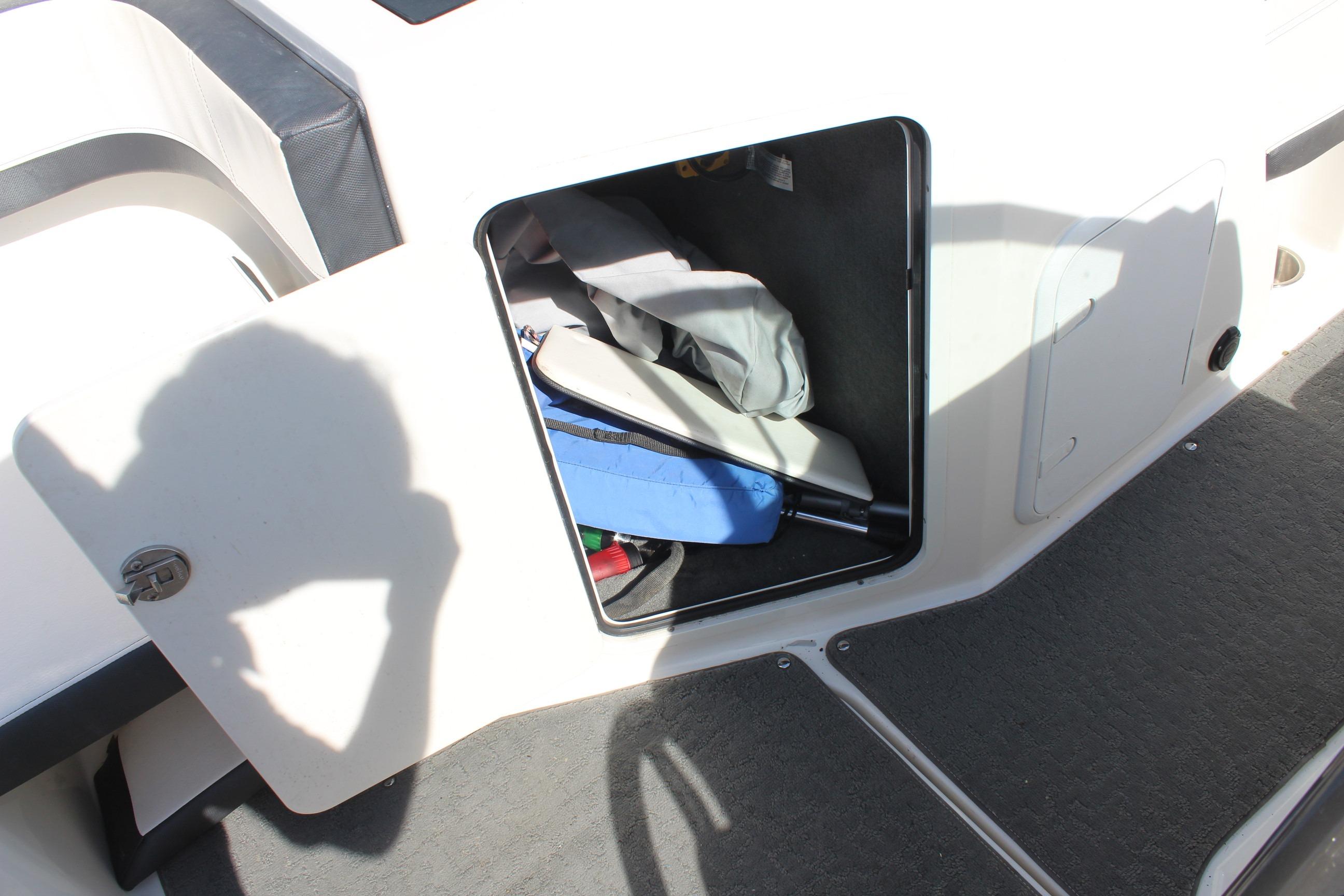Storage compartment on a 2015 Sea Ray 19 SPX OB boat, containing various items.