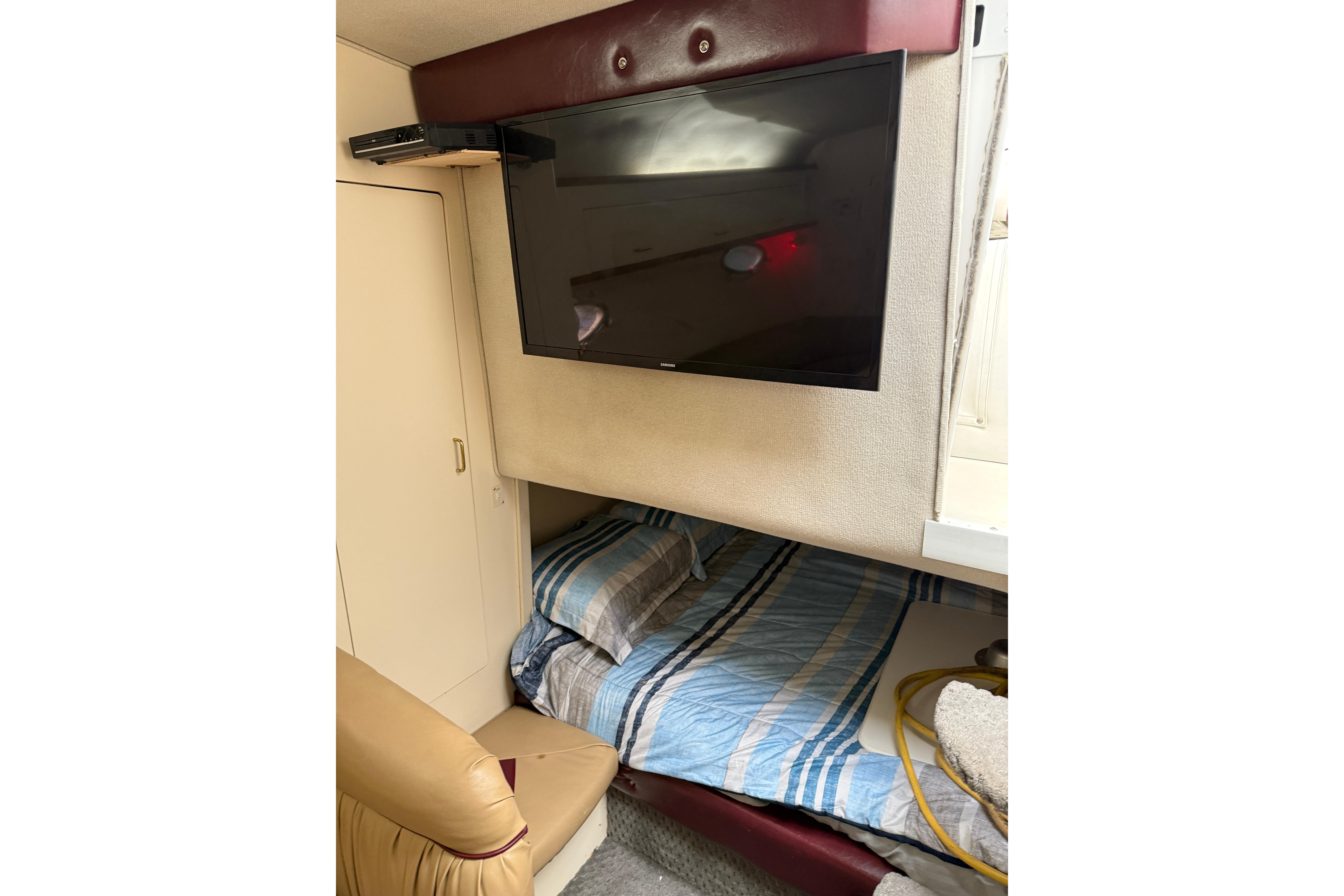 1997 Larson Cabrio 310 Mid-Cabin interior with bed, TV, and storage.