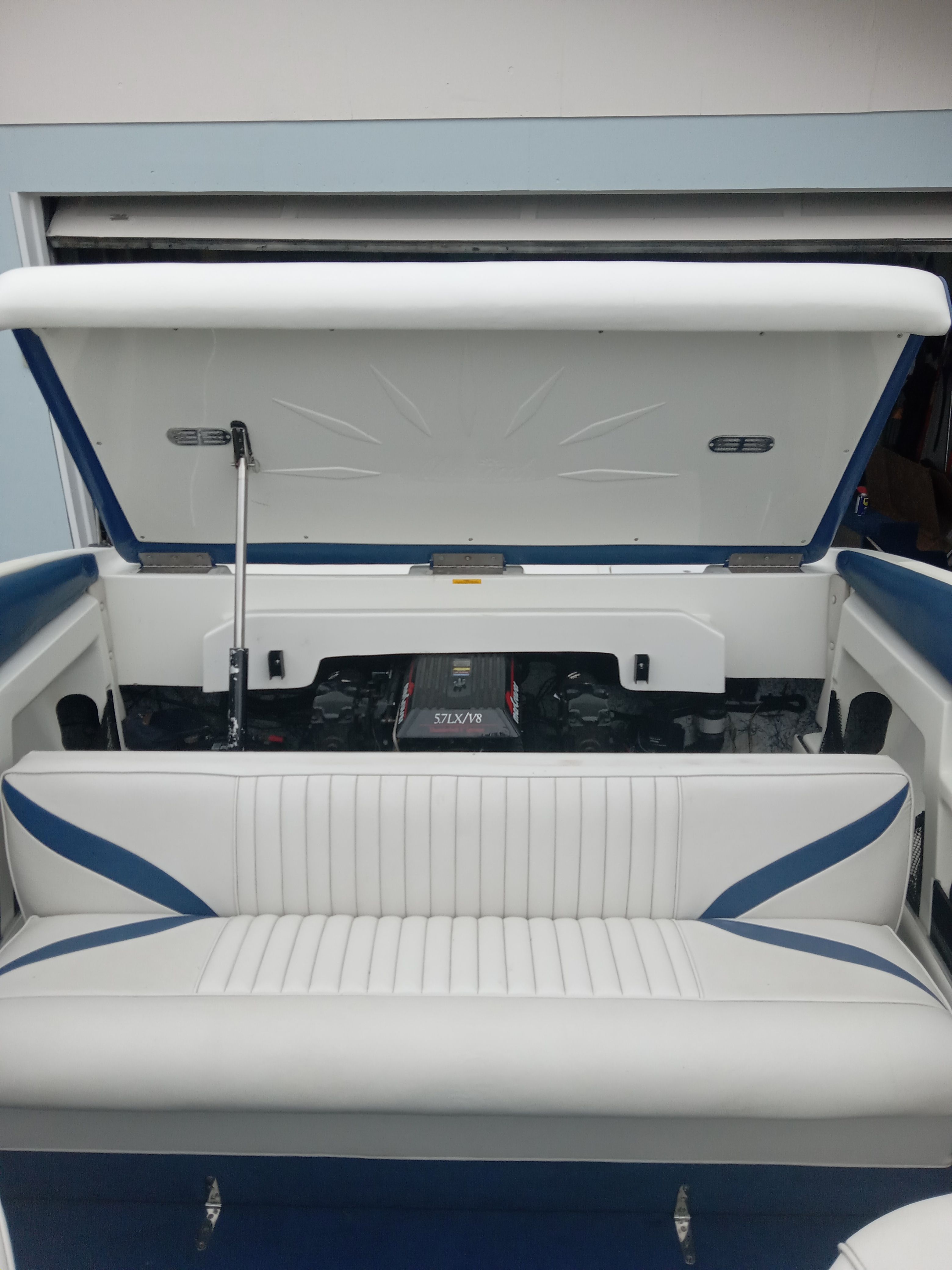 Interior of a 1997 Mariah Z210 Shabah with white and blue seating and open engine compartment.