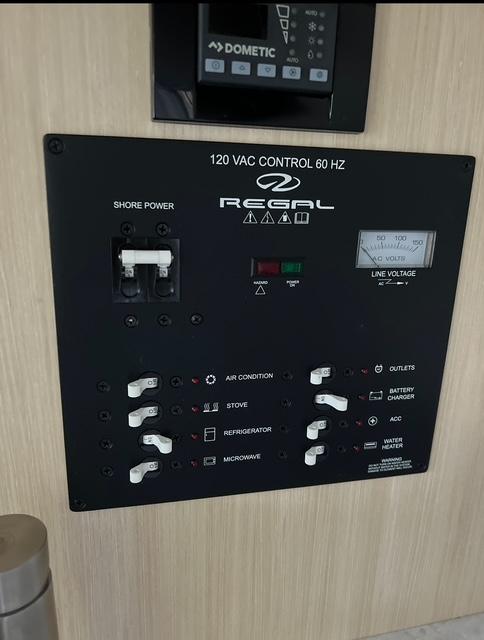 2024 Regal 26 X control panel with switches for air conditioning, stove, refrigerator, and microwave.