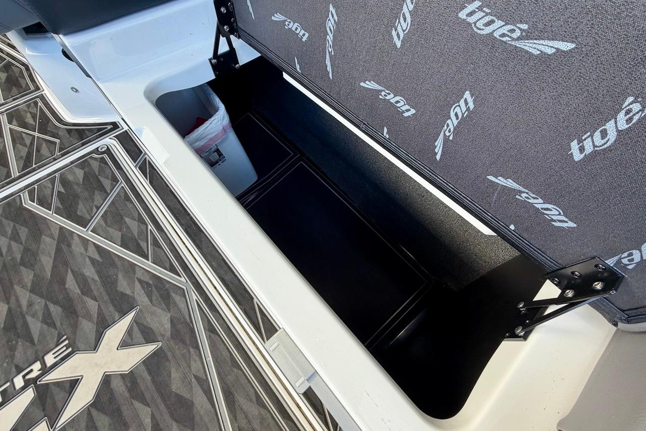 2025 Tigé Ultré 25ZX boat storage compartment with branded interior and geometric flooring design.