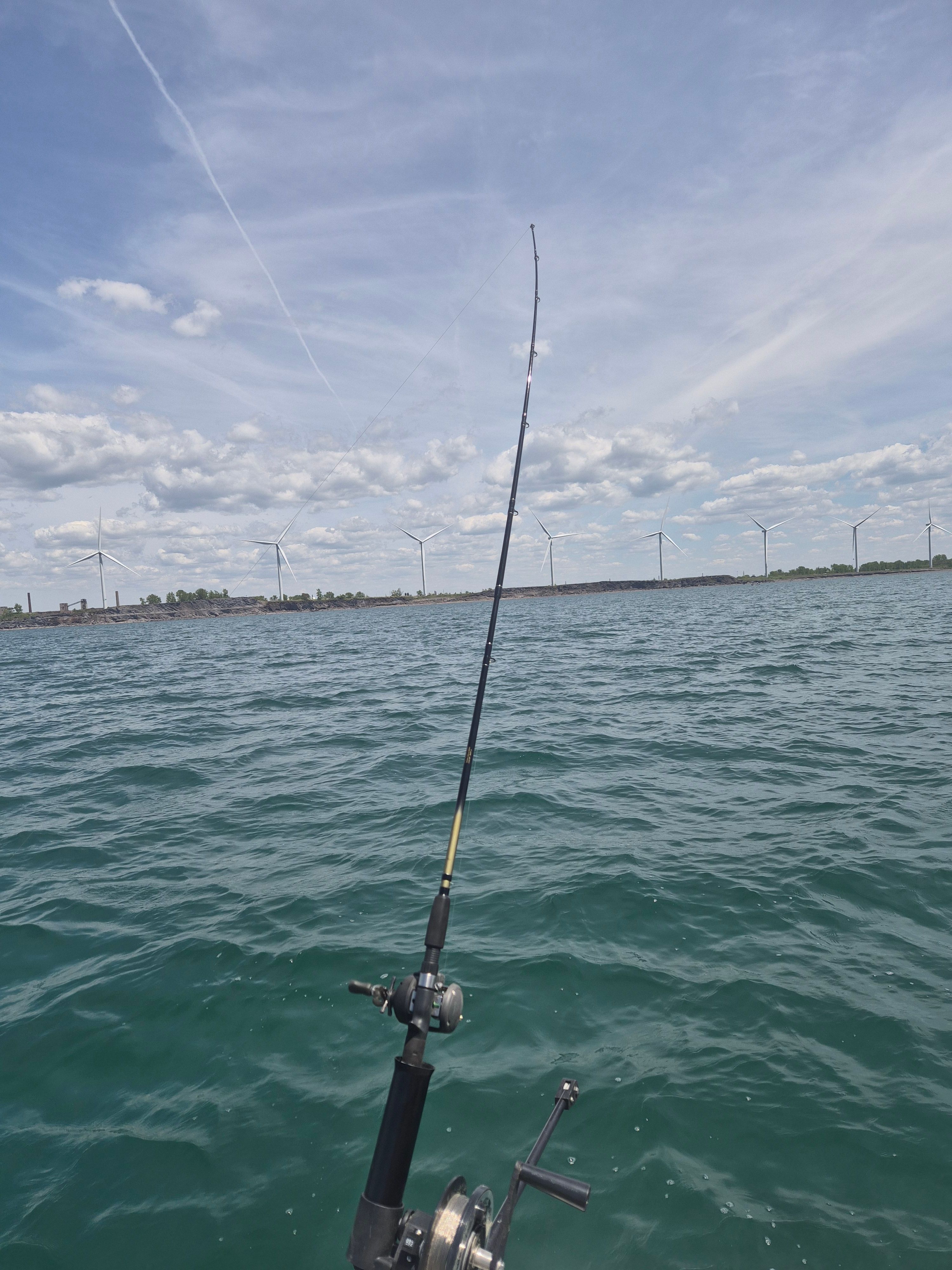 Fishing on a 2019 Scarab 255 Open ID boat with wind turbines in the background.