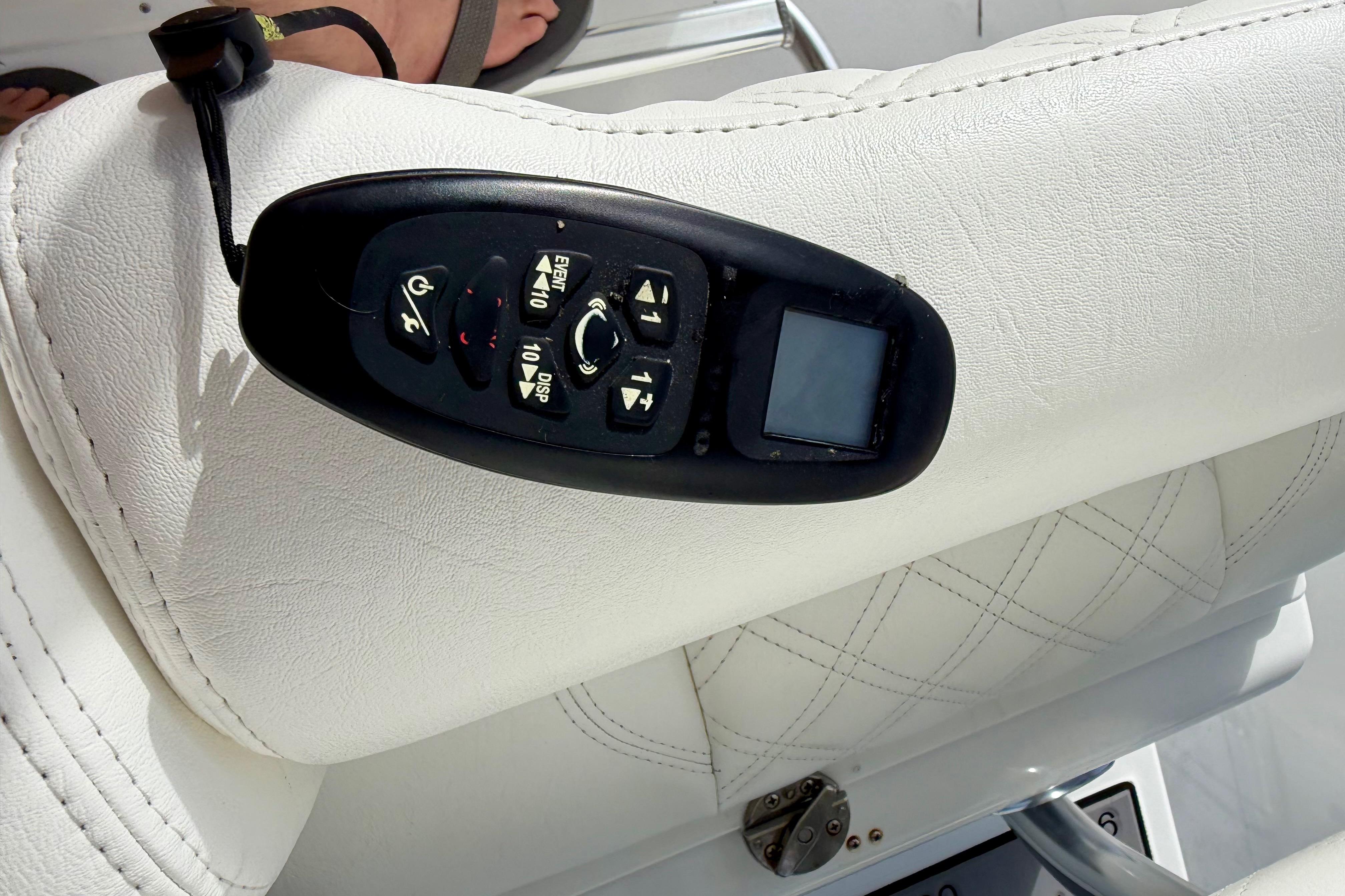Control panel on white leather seat of 2025 Ocean Master 296 Center Console boat.