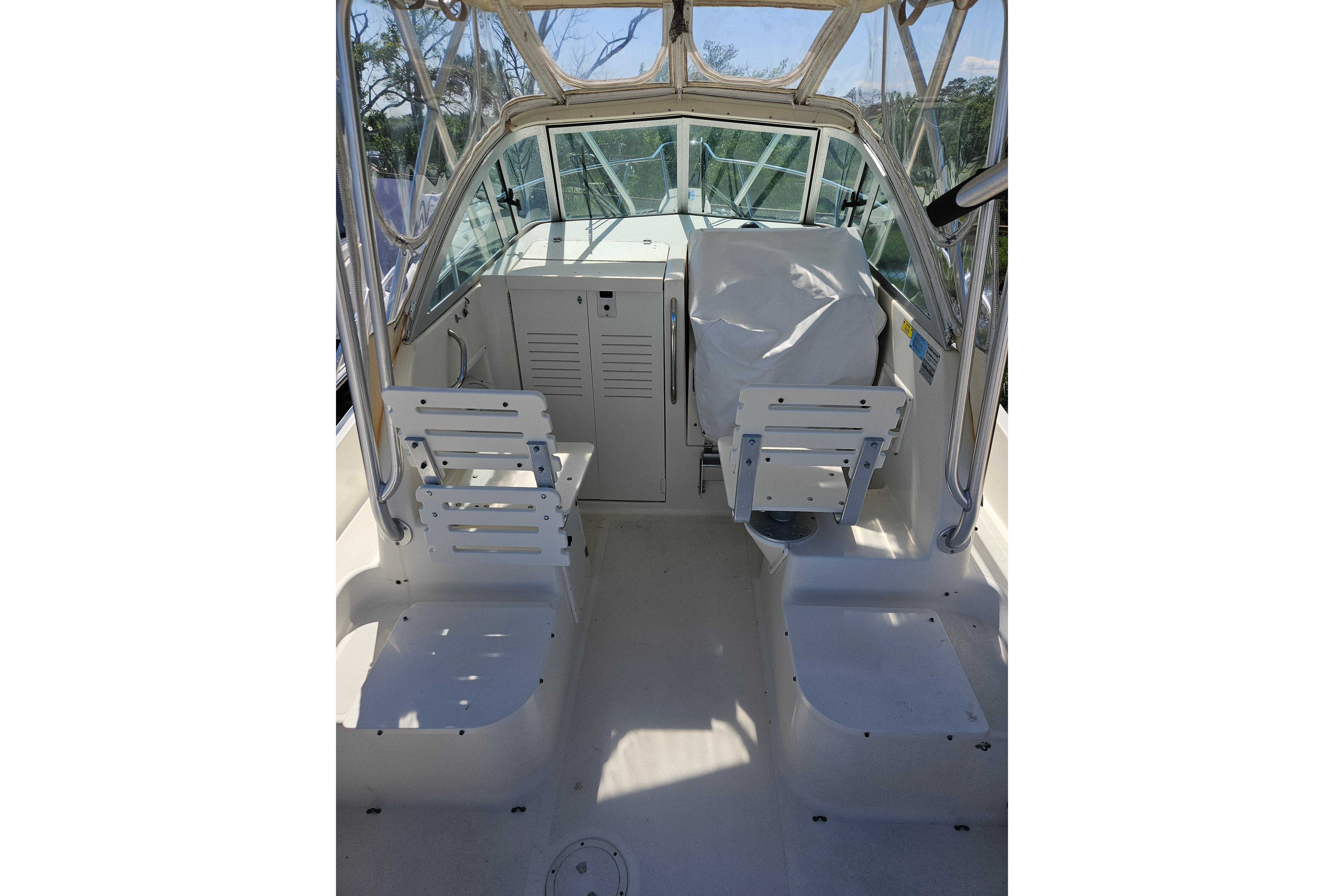 2004 Pursuit 2470 Walkaround boat interior with seating and helm station.