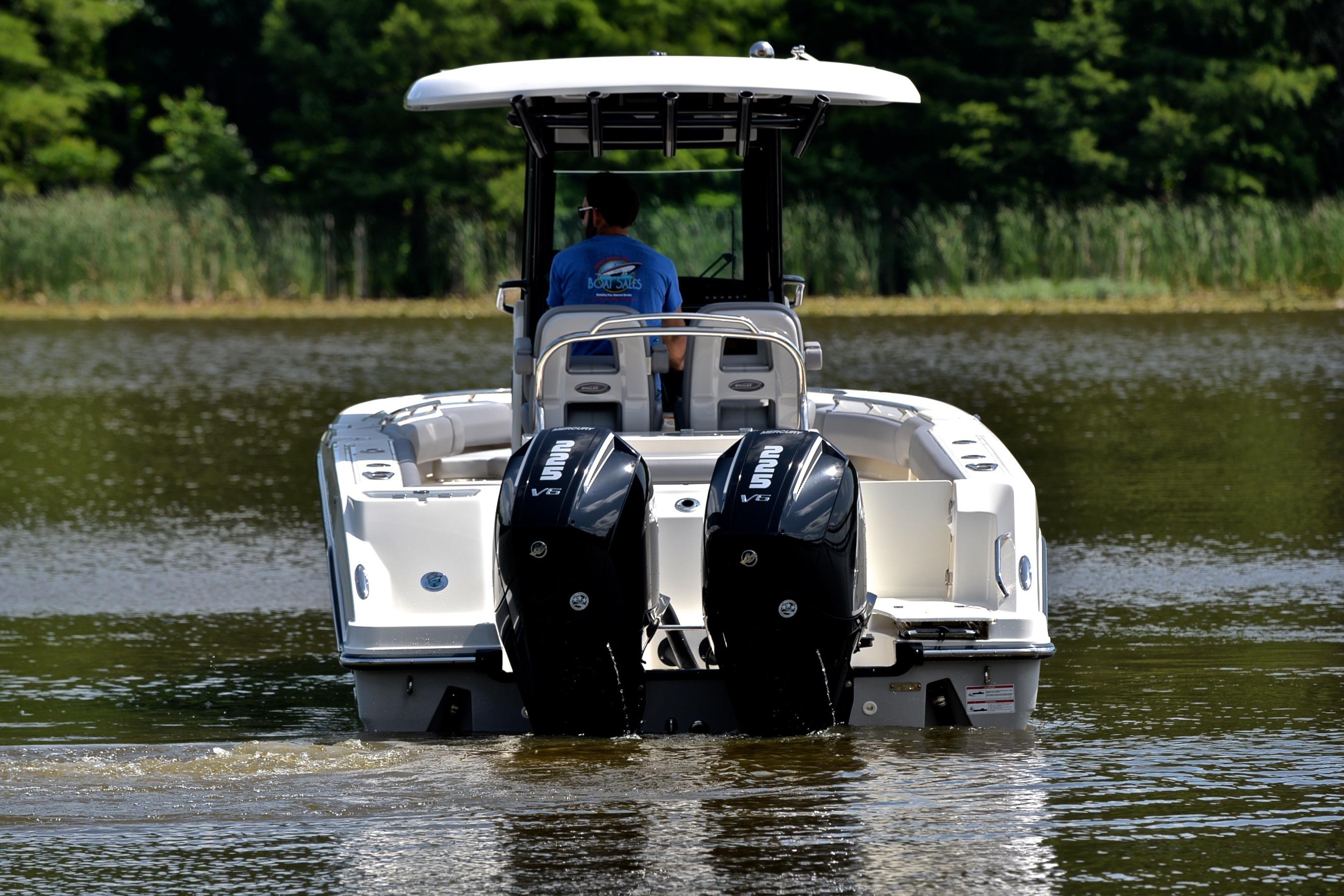 2024 Boston Whaler 250 Outrage boat with dual engines on a calm lake.