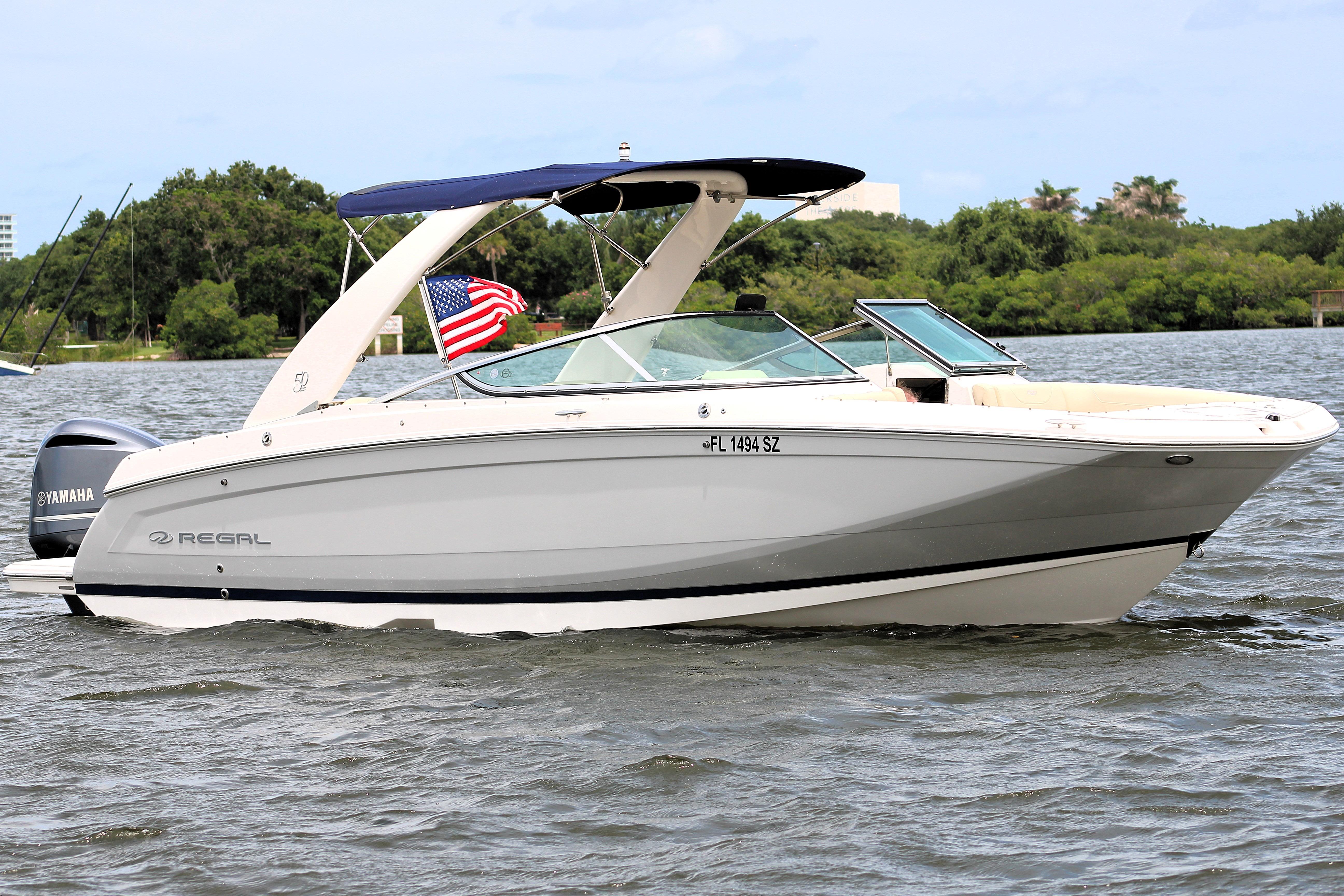 2021 Regal 26 OBX boat on water with American flag and Yamaha engine.