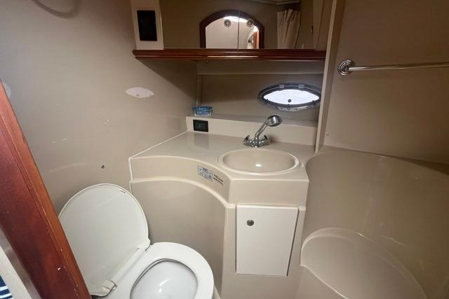 2004 Cruisers Yachts 3372 Express bathroom with sink, toilet, and mirror.