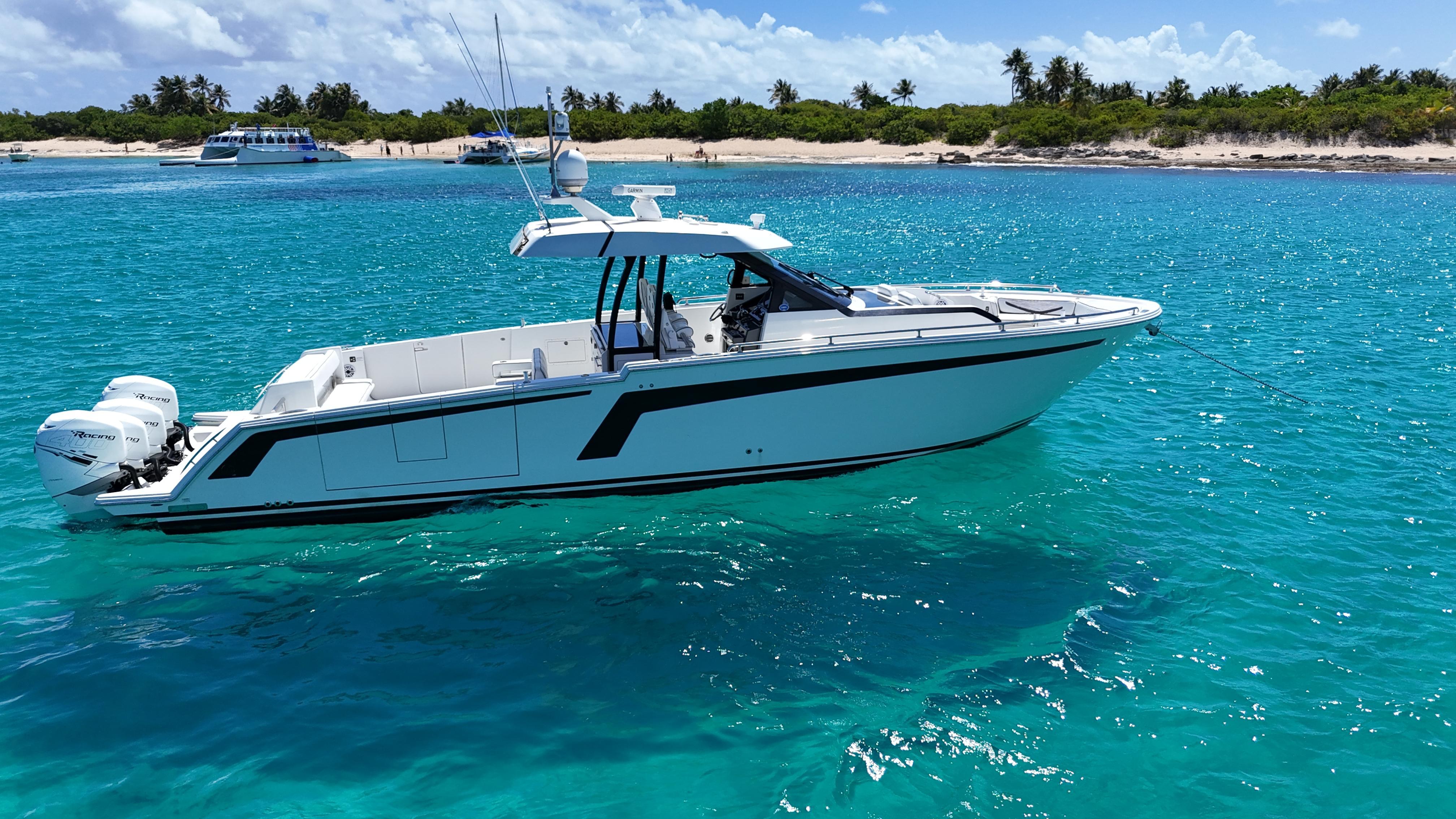 2020 Ocean Alexander 45 Divergence Sport boat on clear turquoise water near a tropical beach.