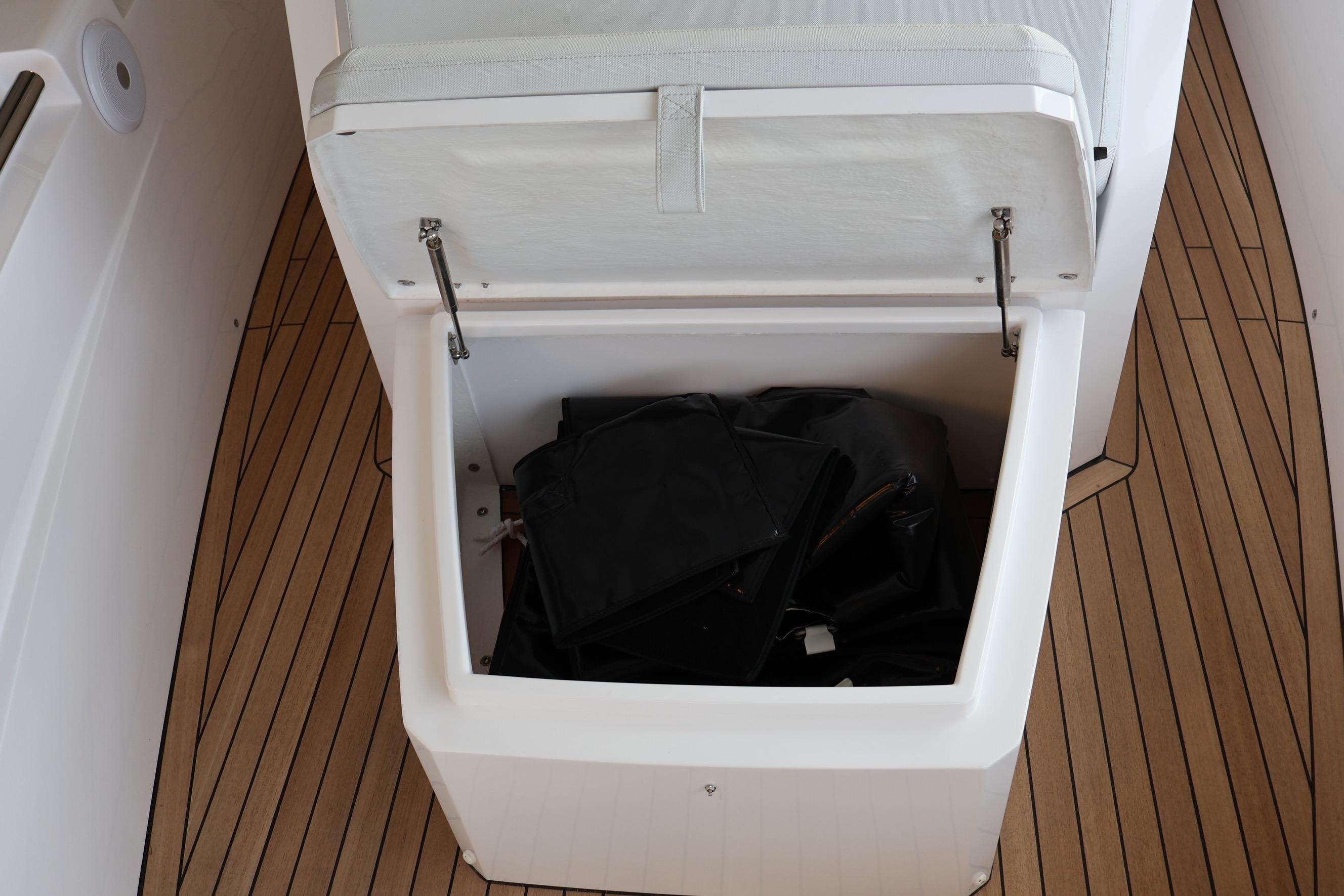 Open storage compartment on 2026 Pirelli 30 boat with teak flooring.