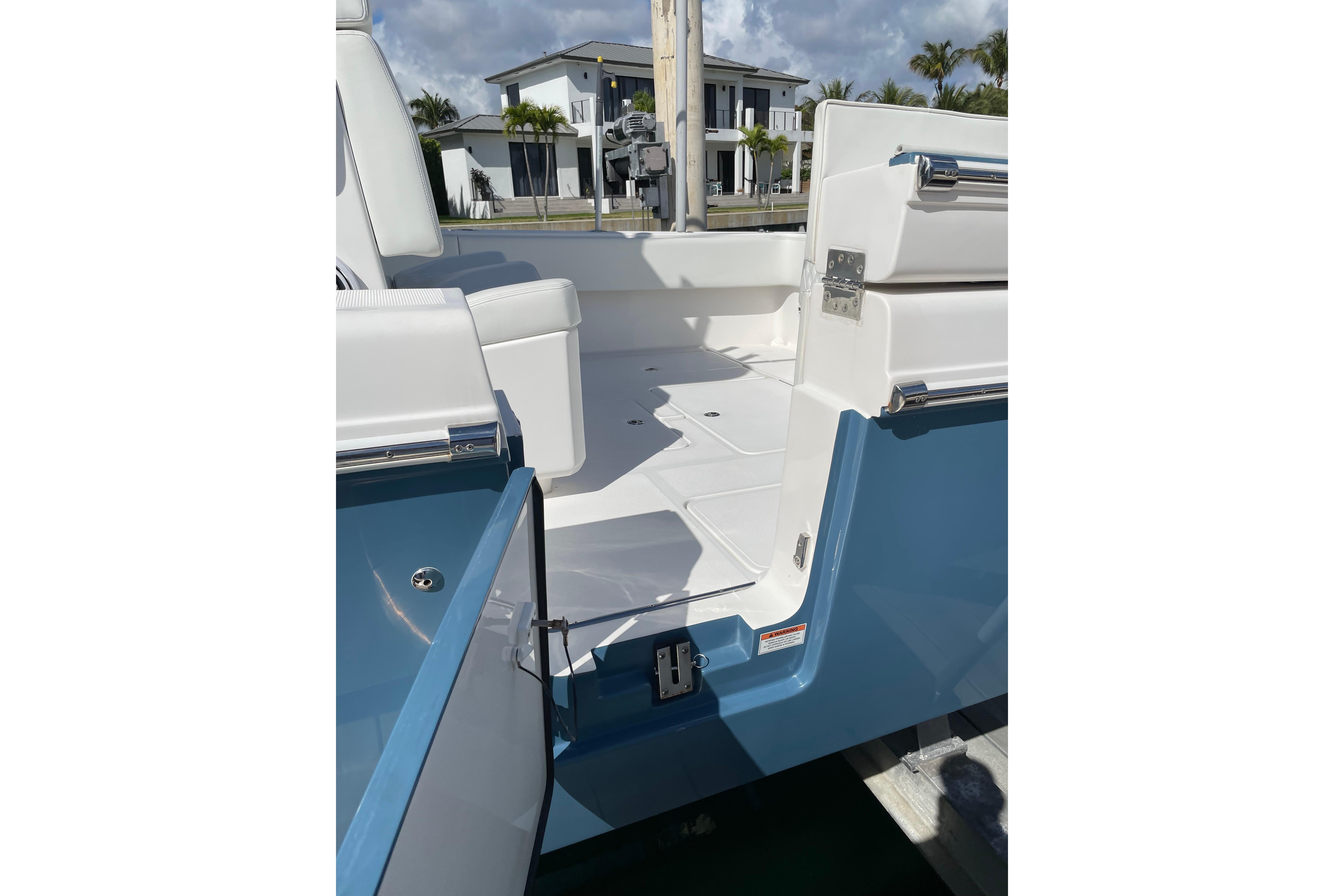 2024 Invincible 36 Open Fisherman boat interior with open door, white seating, and blue exterior.