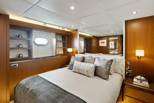 Luxurious bedroom interior on 2006 Tecnomar 35 Nadara yacht, featuring elegant wood paneling.