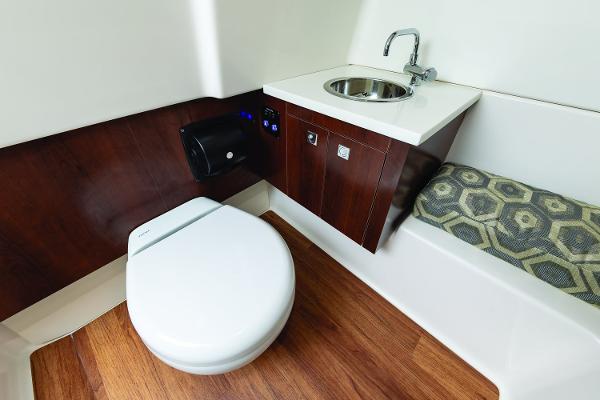 Manufacturer Provided Image: 2019 Chaparral 300 OSX boat bathroom with toilet, sink, and wooden flooring.
