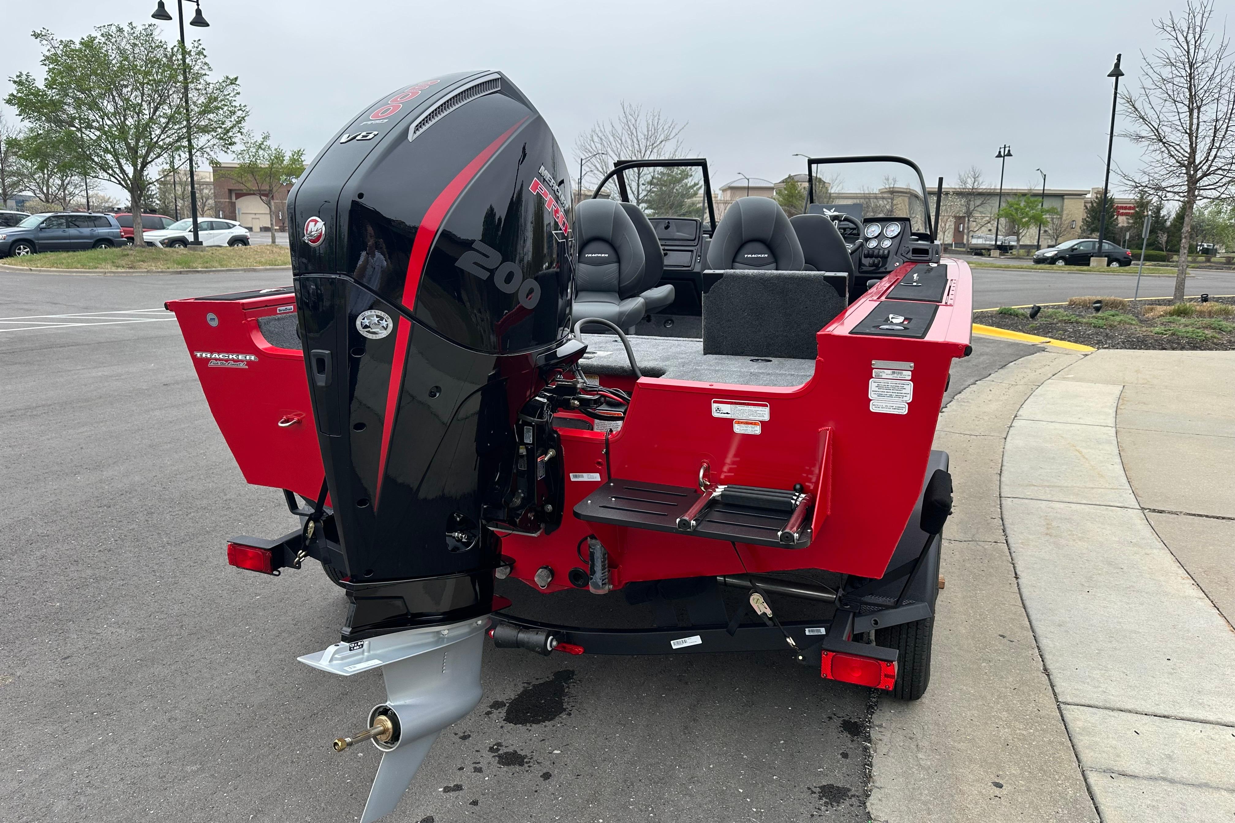 2026 Tracker Targa V-19 Combo boat with powerful outboard motor, parked in a lot.