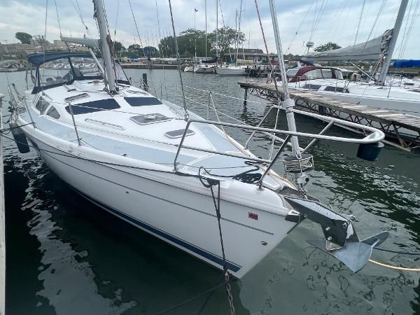 A 2000 Hunter 410 sailboat docked in a marina, surrounded by other boats.