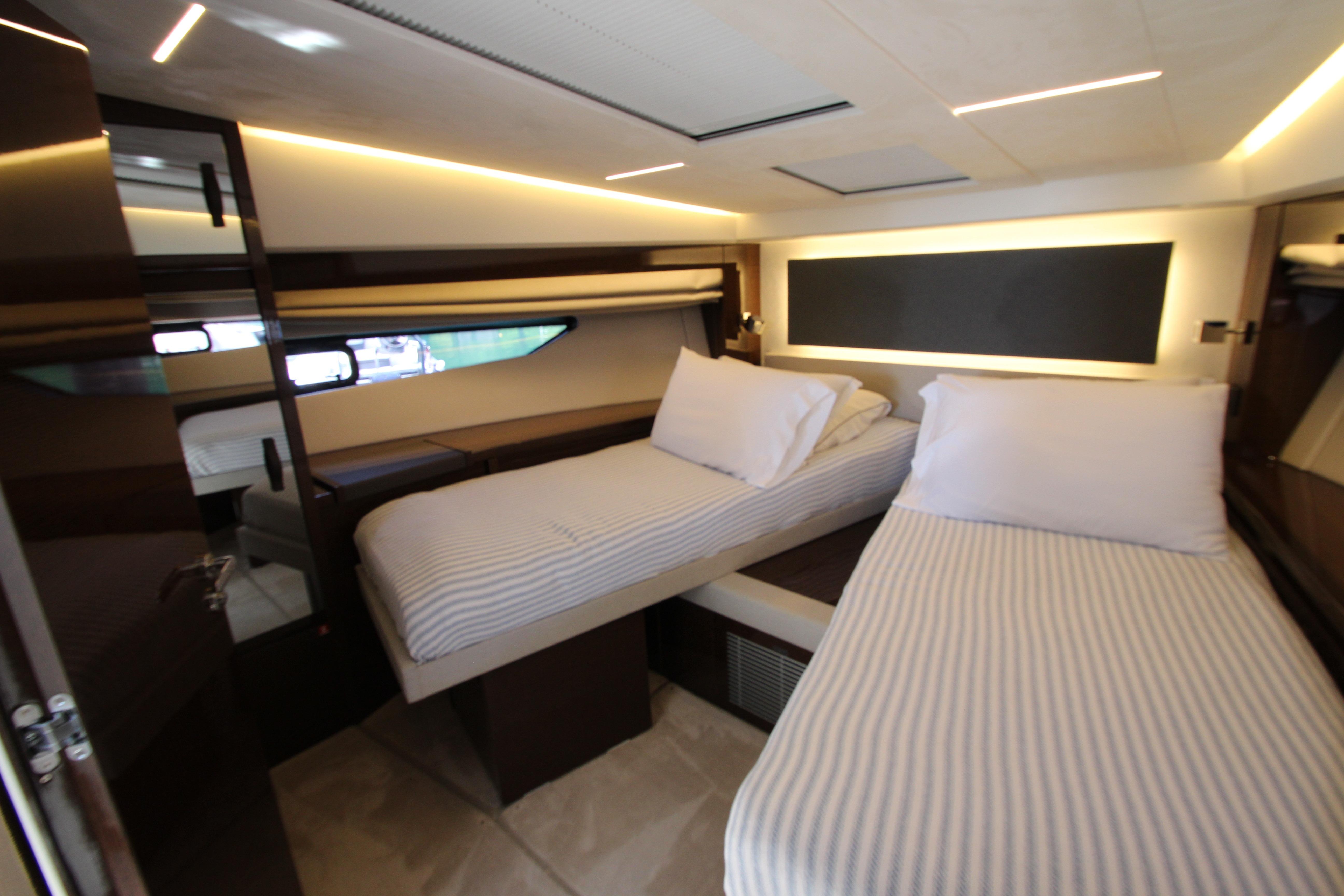Luxurious twin cabin interior of 2022 Prestige 520 yacht with modern lighting.