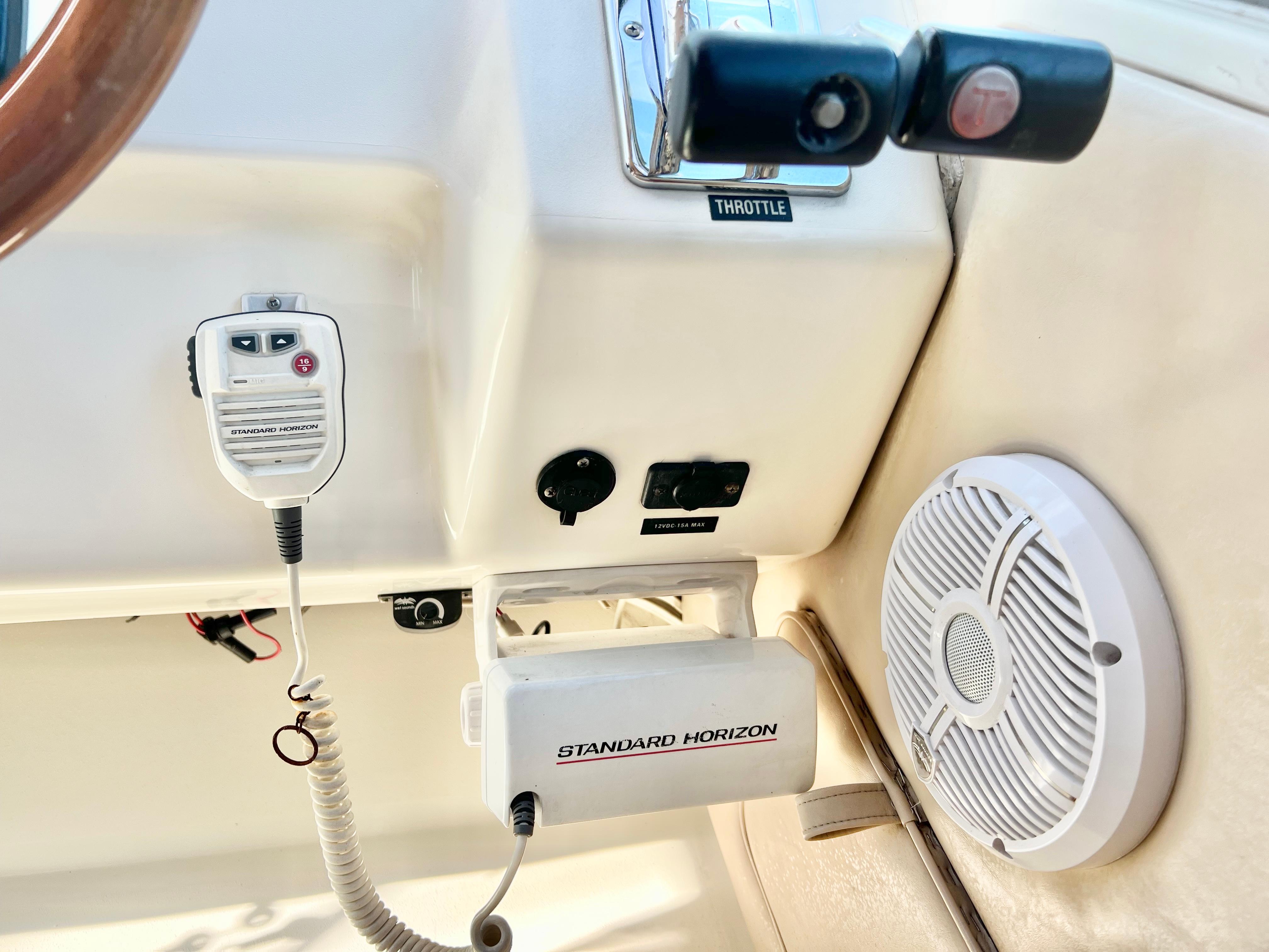1995 Sea Ray 300 Sundancer dashboard with radio, throttle, and speaker.