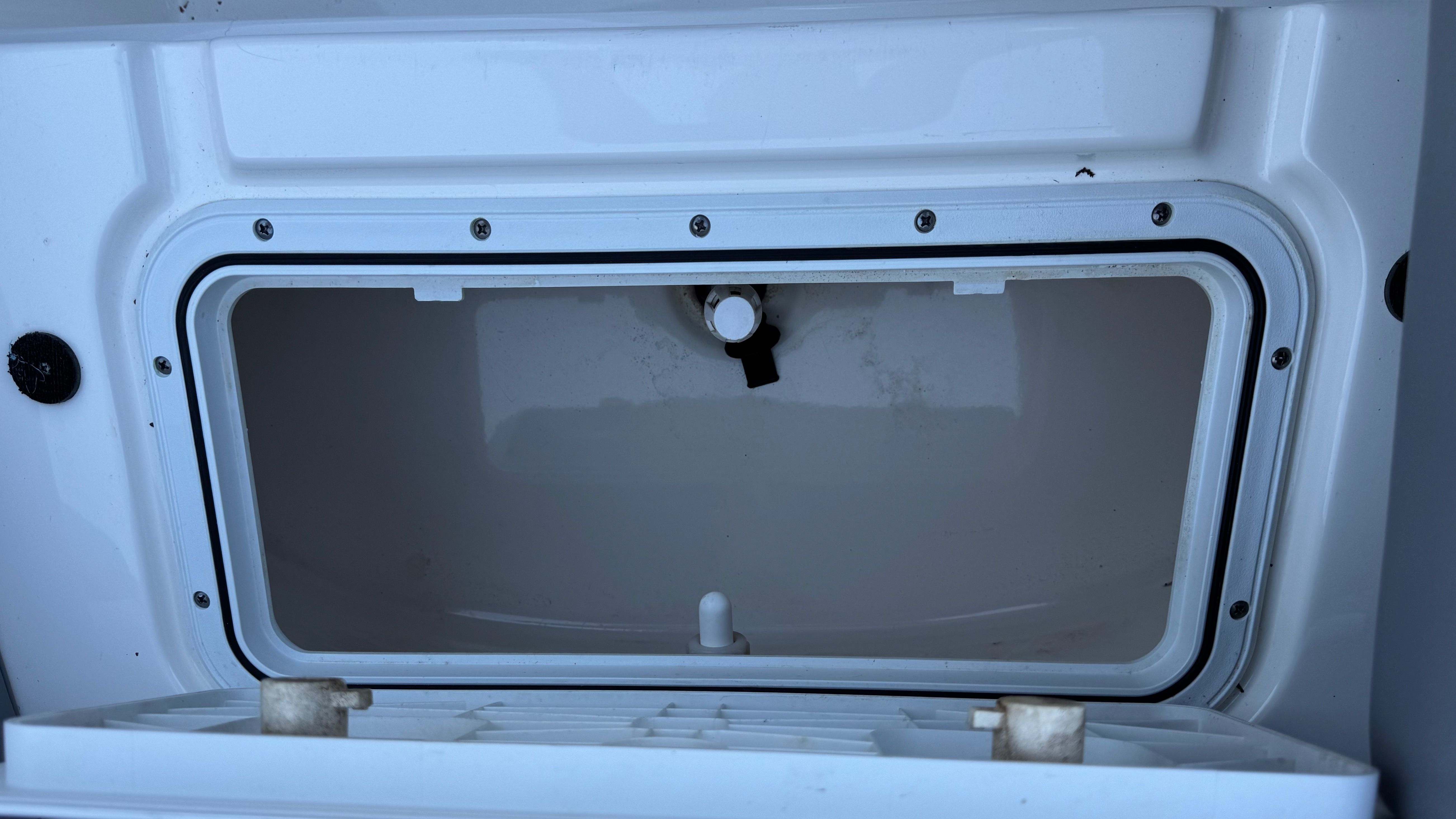 An open storage compartment on a 2022 NauticStar 243 DC boat.