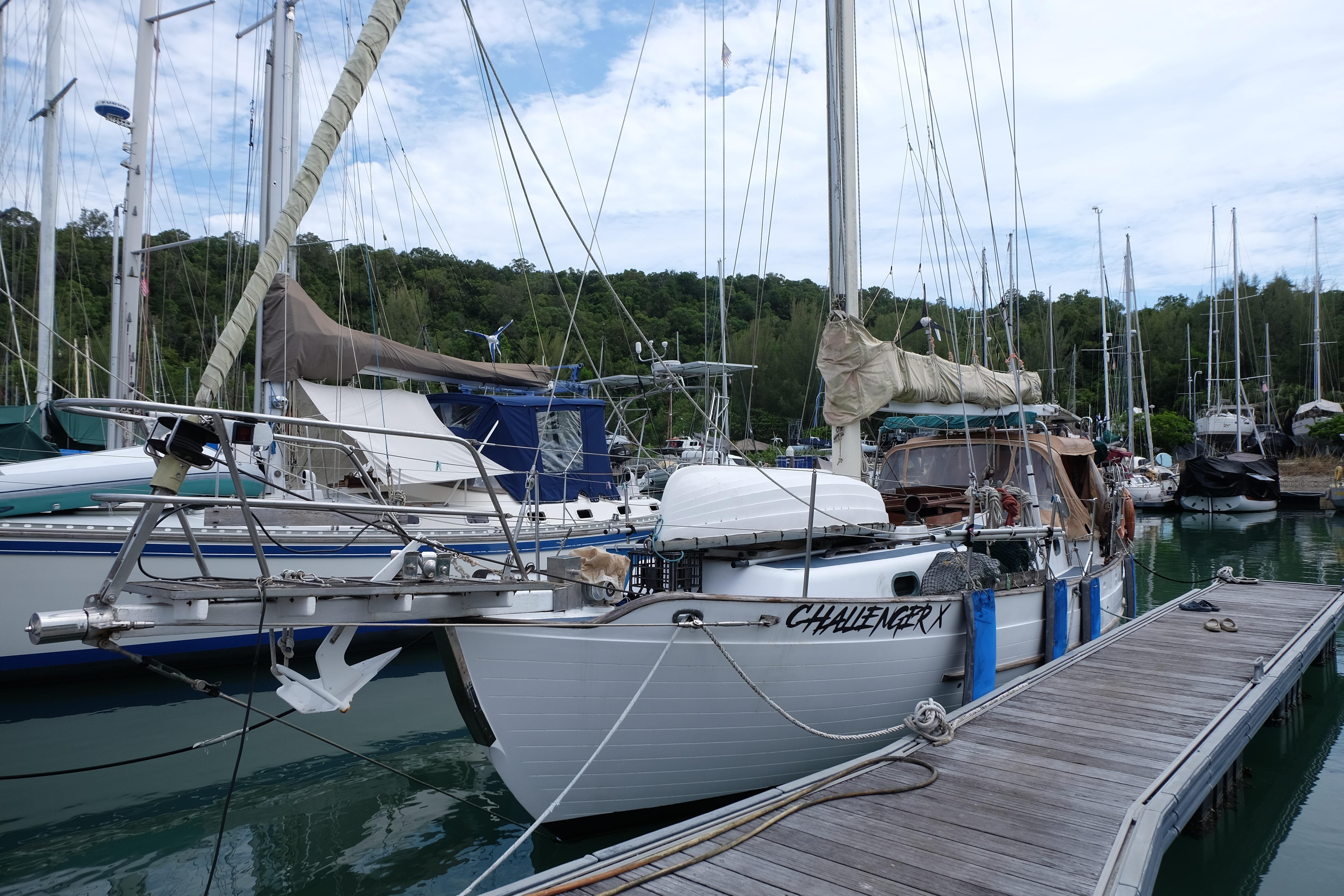 1979 Westwind 35 sailboat docked at marina with lush green backdrop.