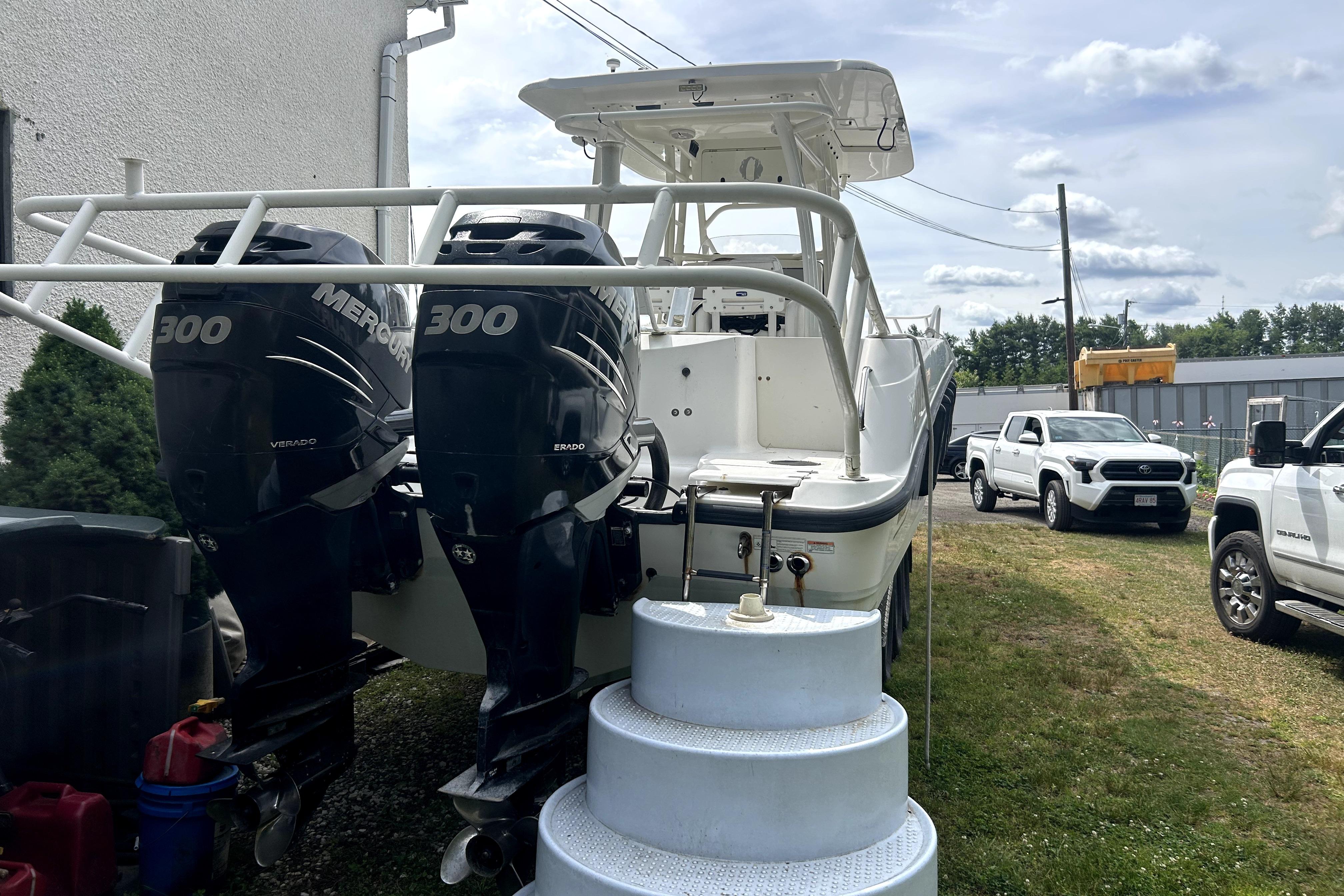 2012 Boston Whaler 320 Outrage with twin Mercury 300 engines, parked outdoors.