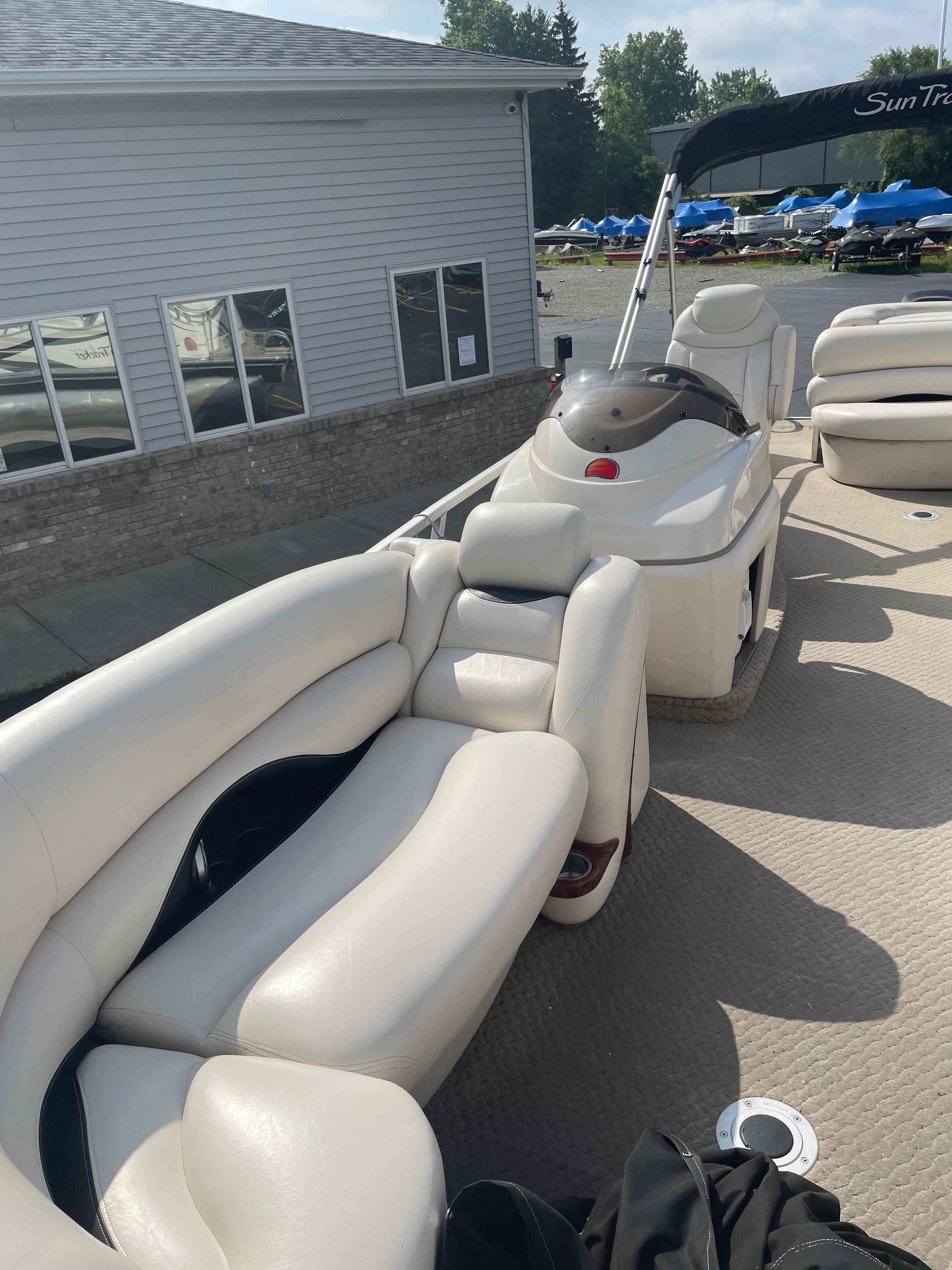 A luxurious pontoon boat with comfortable white seating and a helm station.