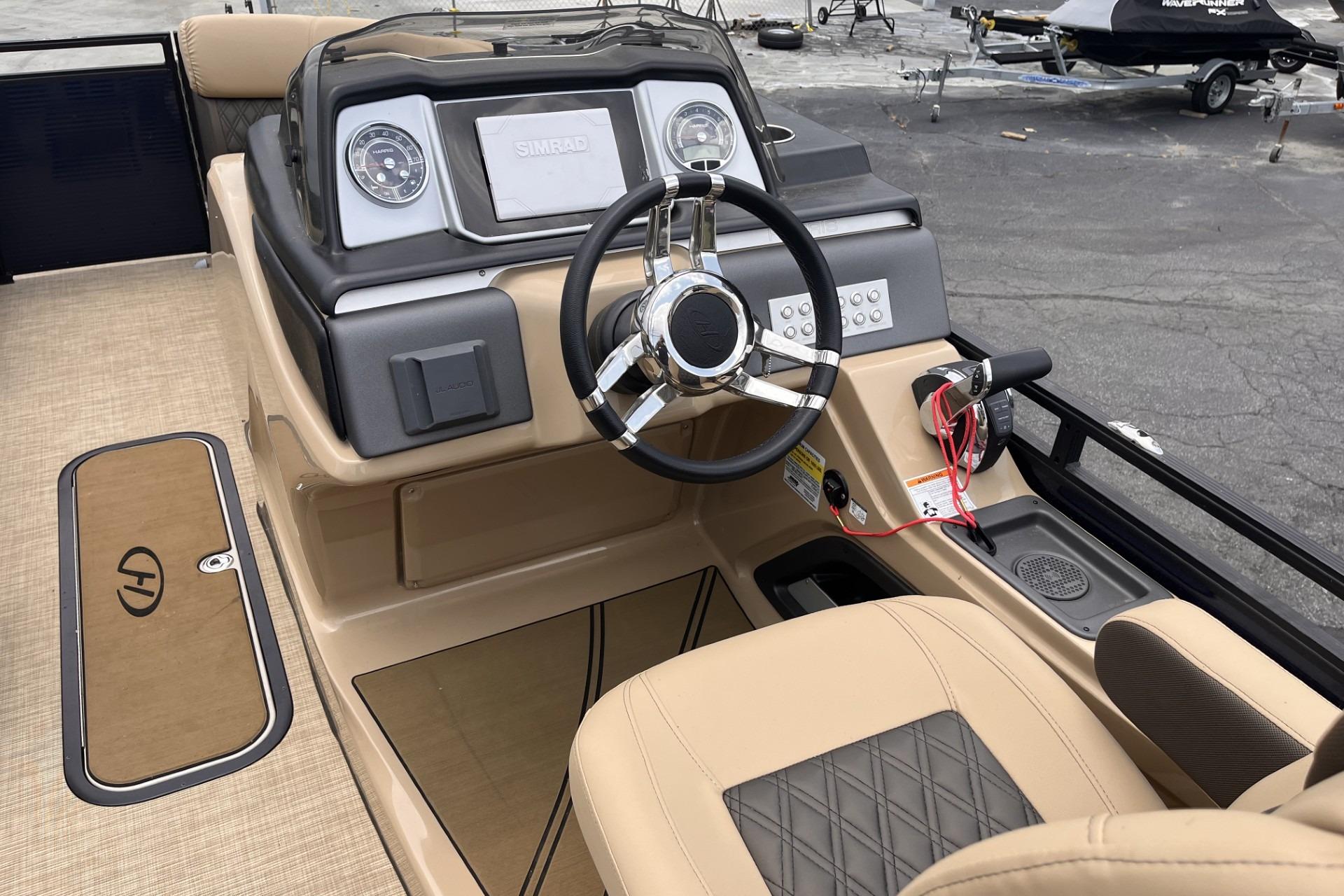 2022 Harris Solstice 230 CWDH boat dashboard with steering wheel and control panel.