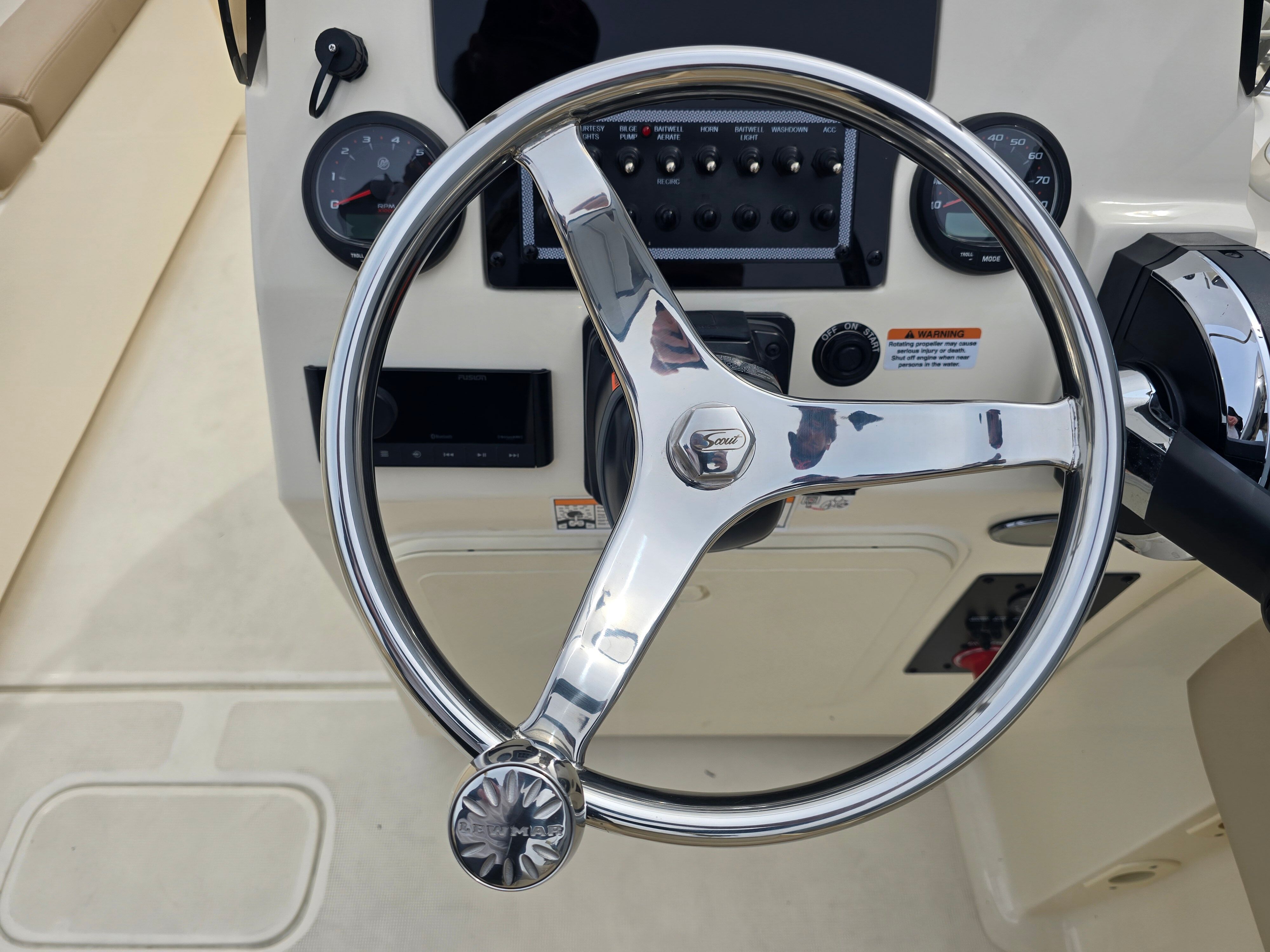 Helm of a 2022 Scout 195 Sport Dorado with shiny steering wheel and instruments.