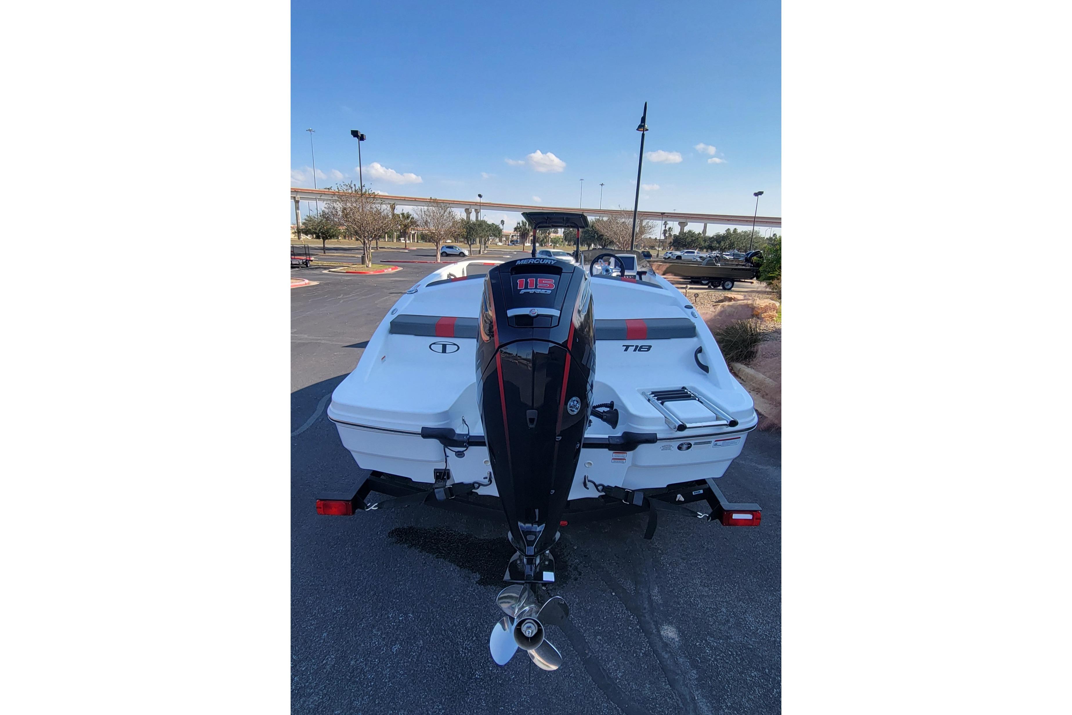 2025 Tahoe T18 boat with outboard motor in a parking lot.