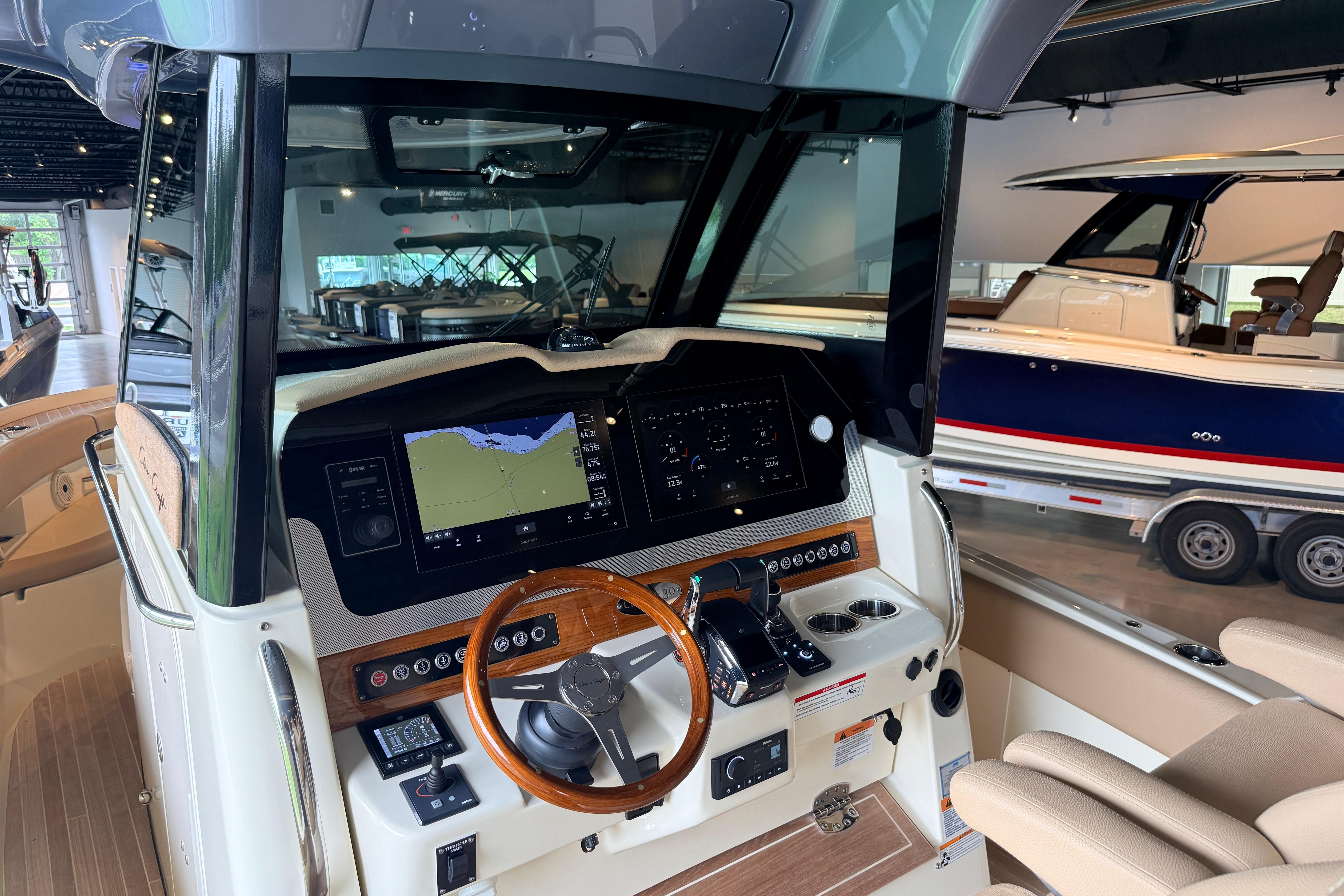 2024 Chris-Craft Catalina 30 helm with advanced navigation system and wooden steering wheel.