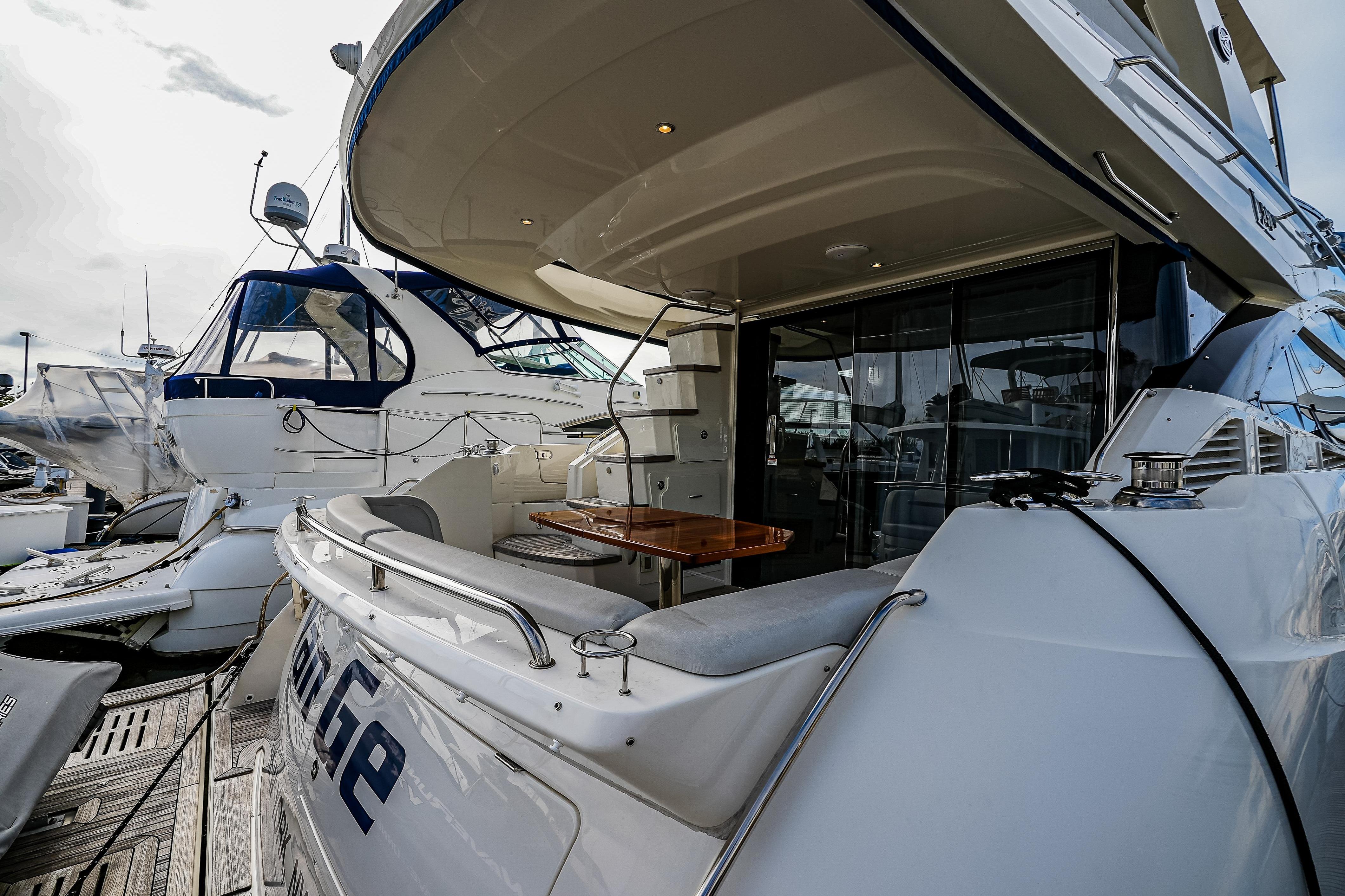 2018 Sea Ray L590 Fly yacht docked, featuring spacious deck and luxurious seating area.