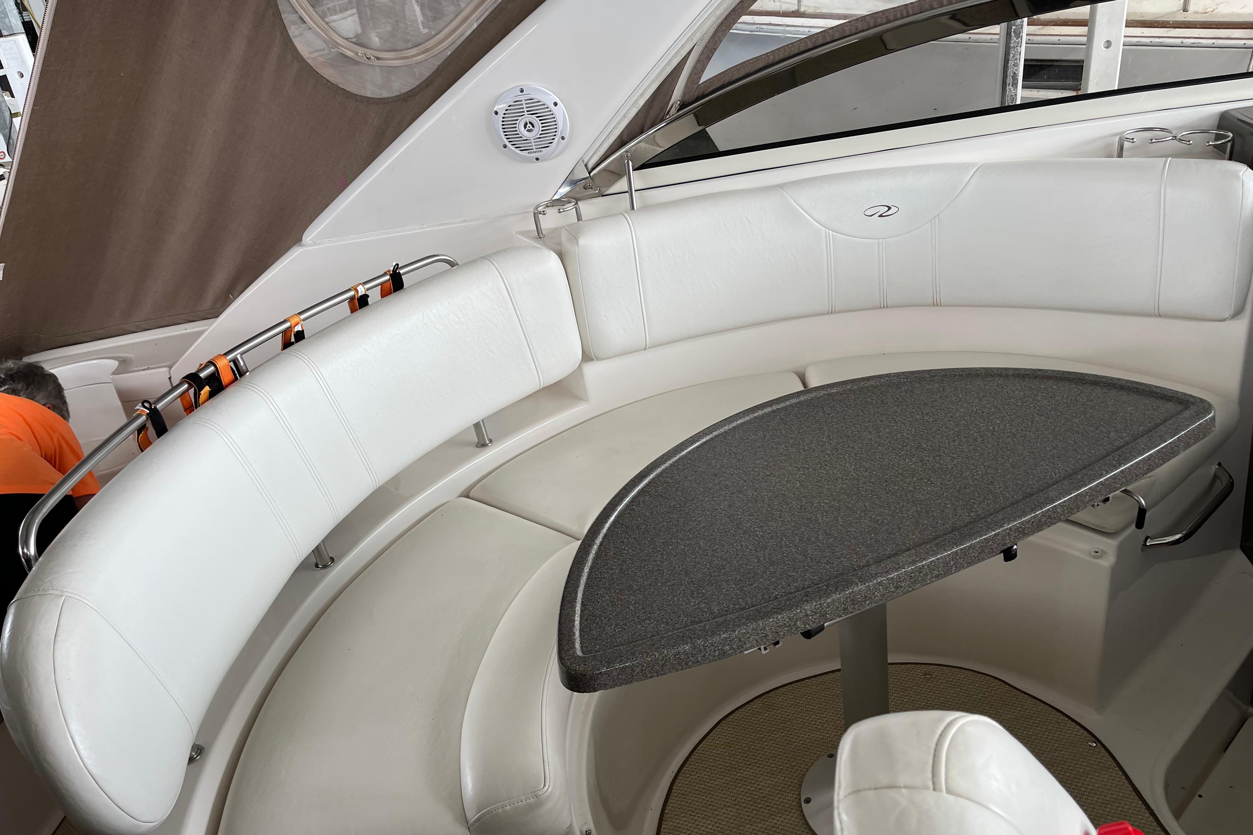 2007 Regal 3760 IB Commodore boat interior with white seating and a curved table.