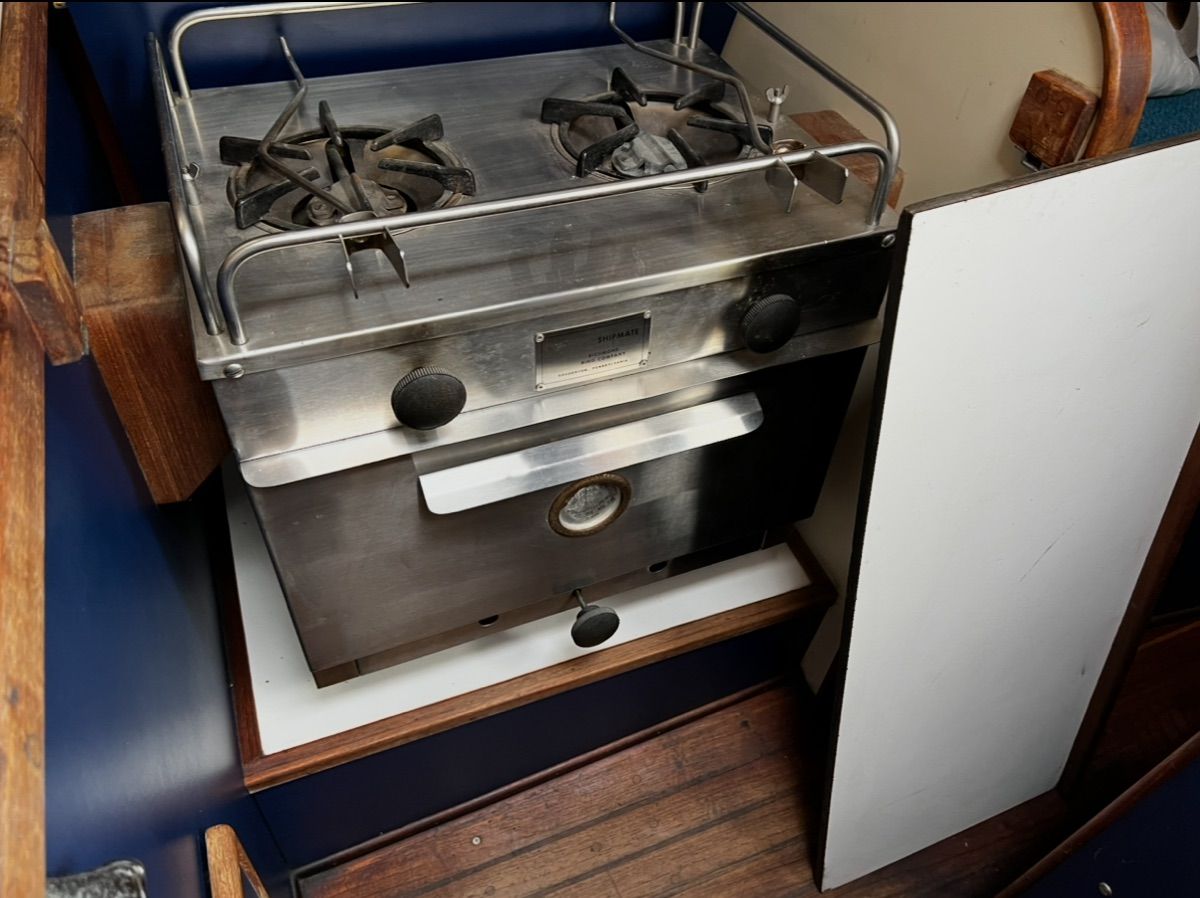 A stainless steel stove with two burners in a boat's galley.