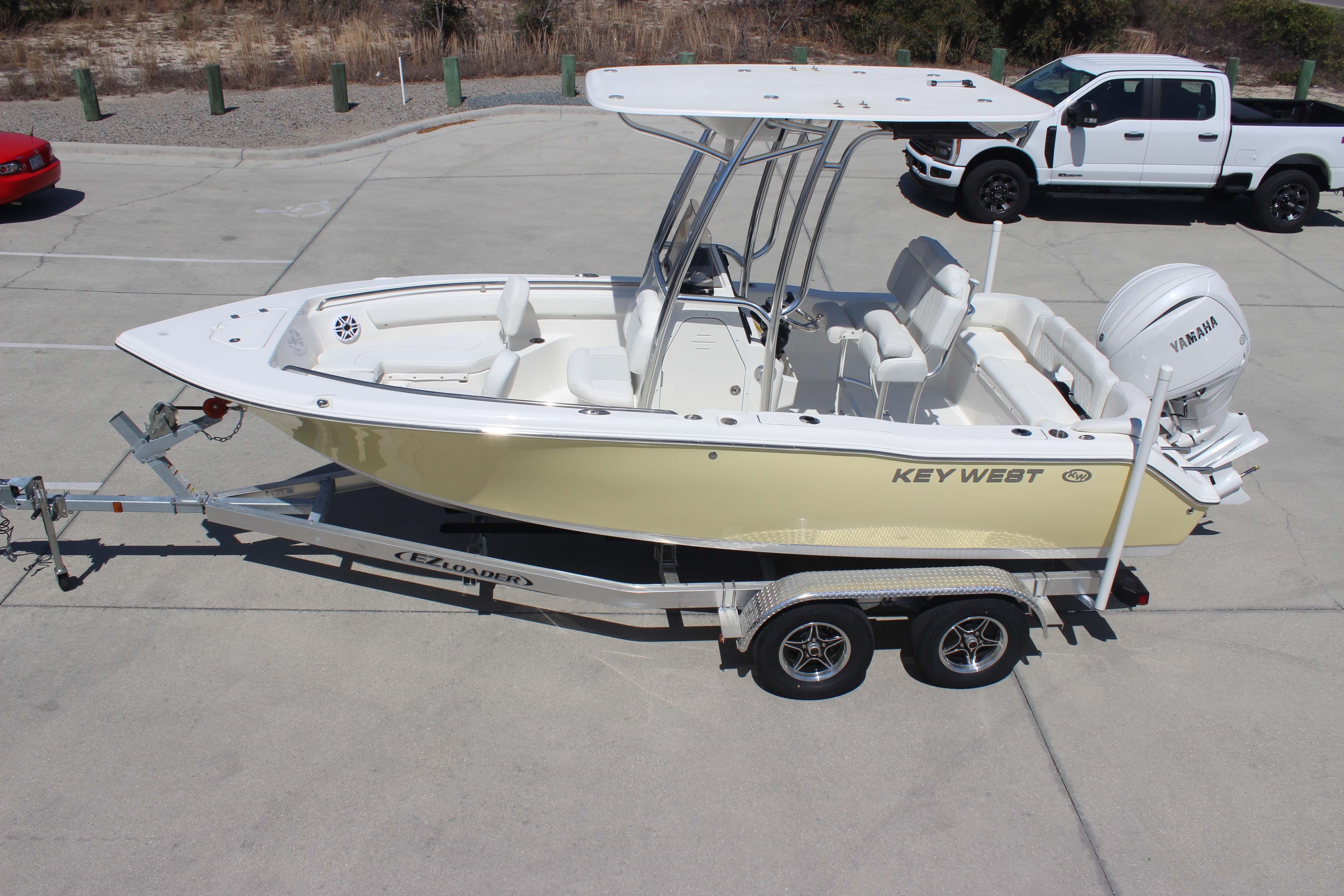 2026 Key West 203 FS boat on trailer, parked in a lot with vehicles nearby.