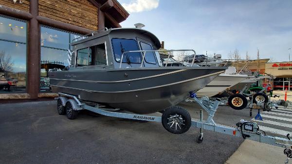 2023 Spartan 220 Maximus boat on trailer outside a store.