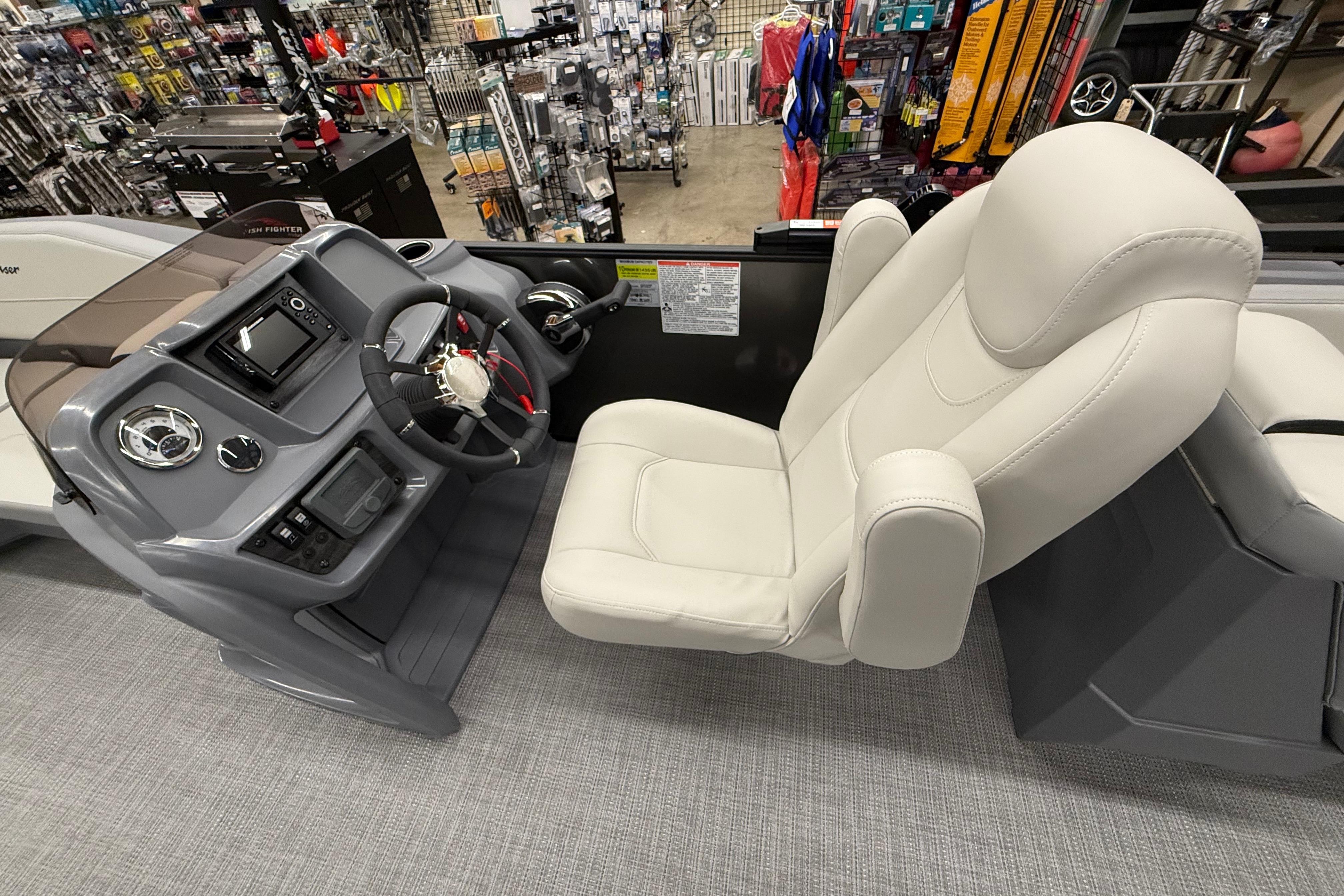Captain's seat and helm of 2025 SunChaser Lucerne 22 LR DH boat in showroom.