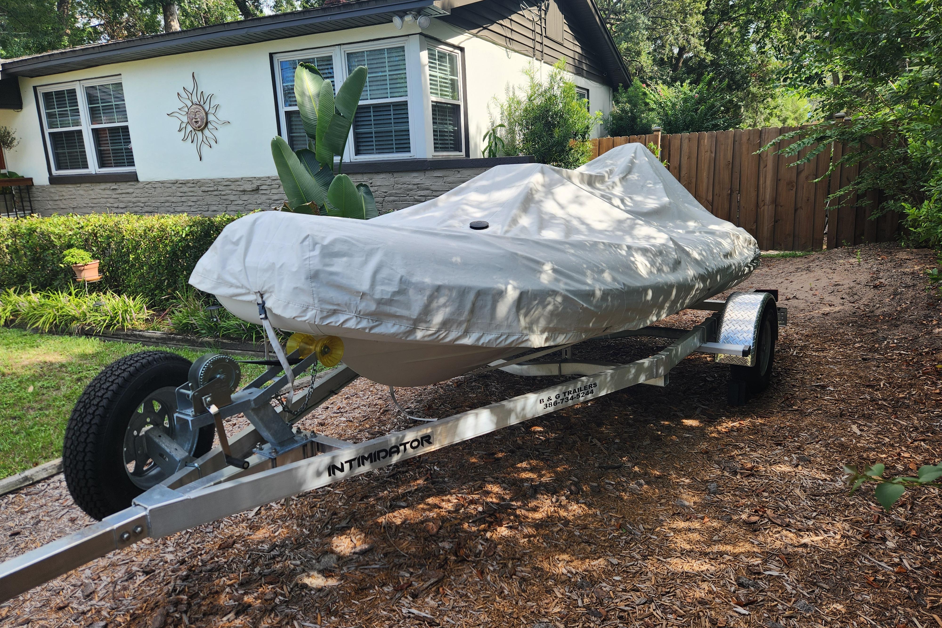 Covered 2019 Novurania DL 400 boat on trailer in residential driveway.