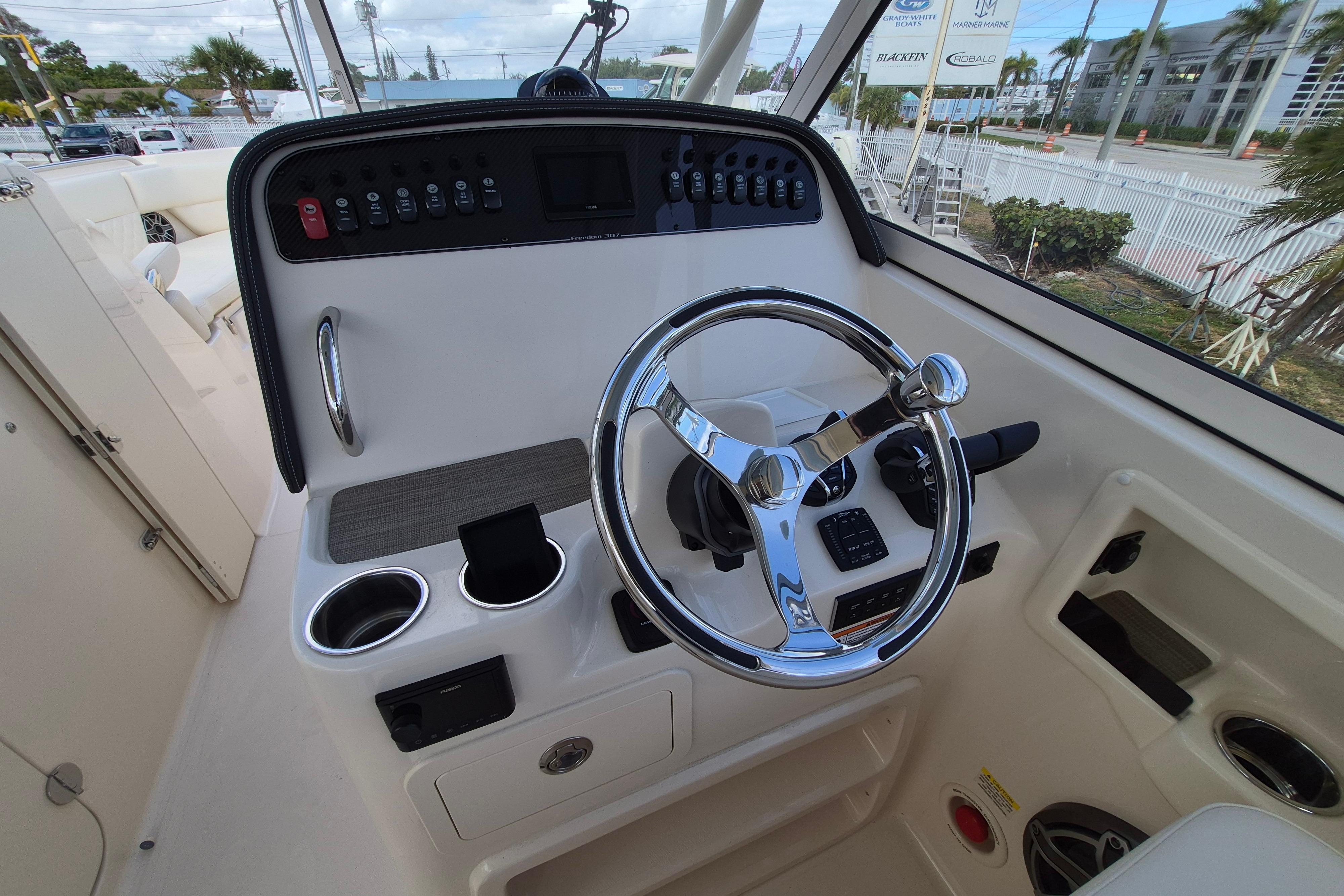 2026 Grady-White Freedom 307 boat helm with chrome steering wheel and control panel.