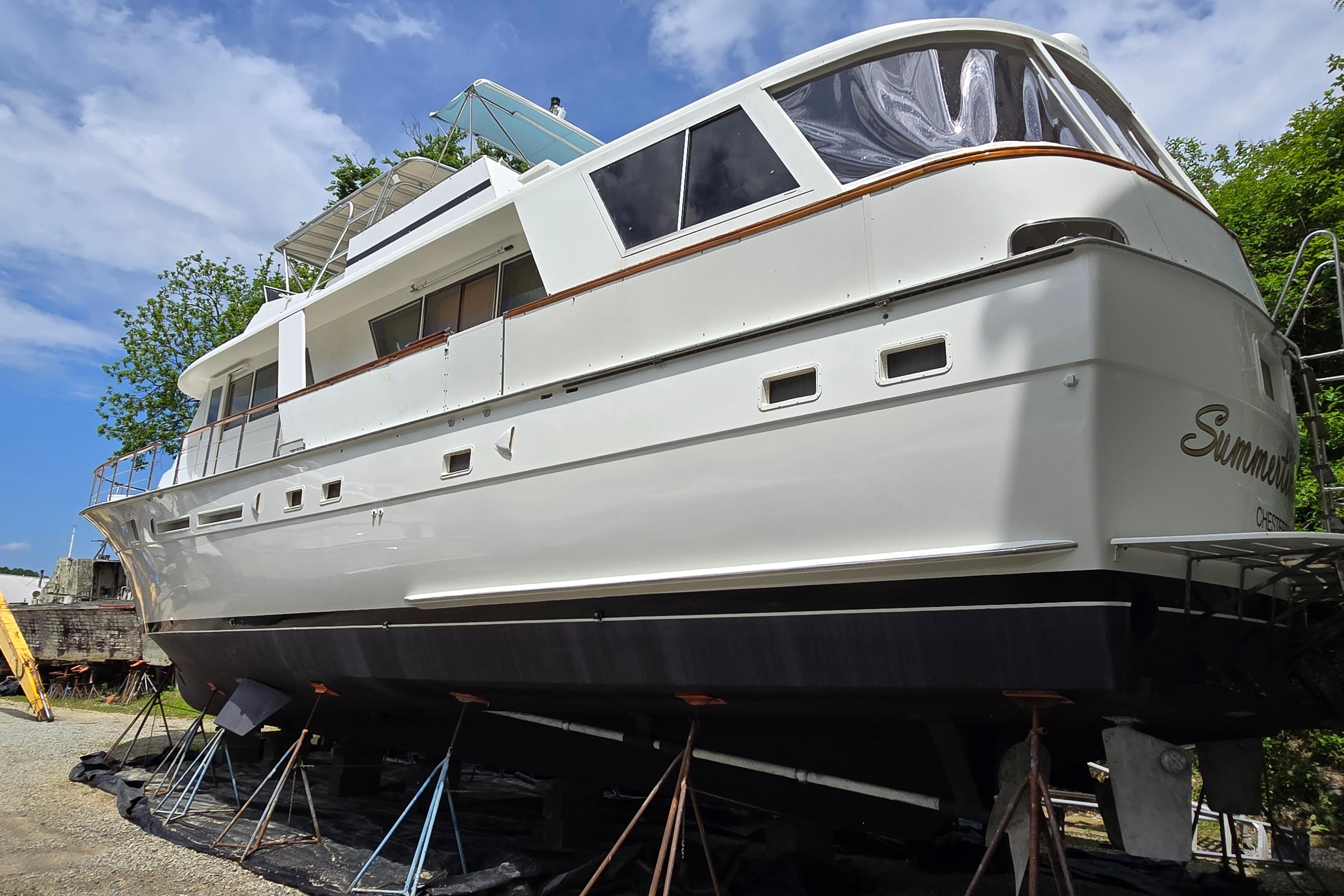 1980 Hatteras 70 Motor Yacht on stands, white exterior, clear sky background.