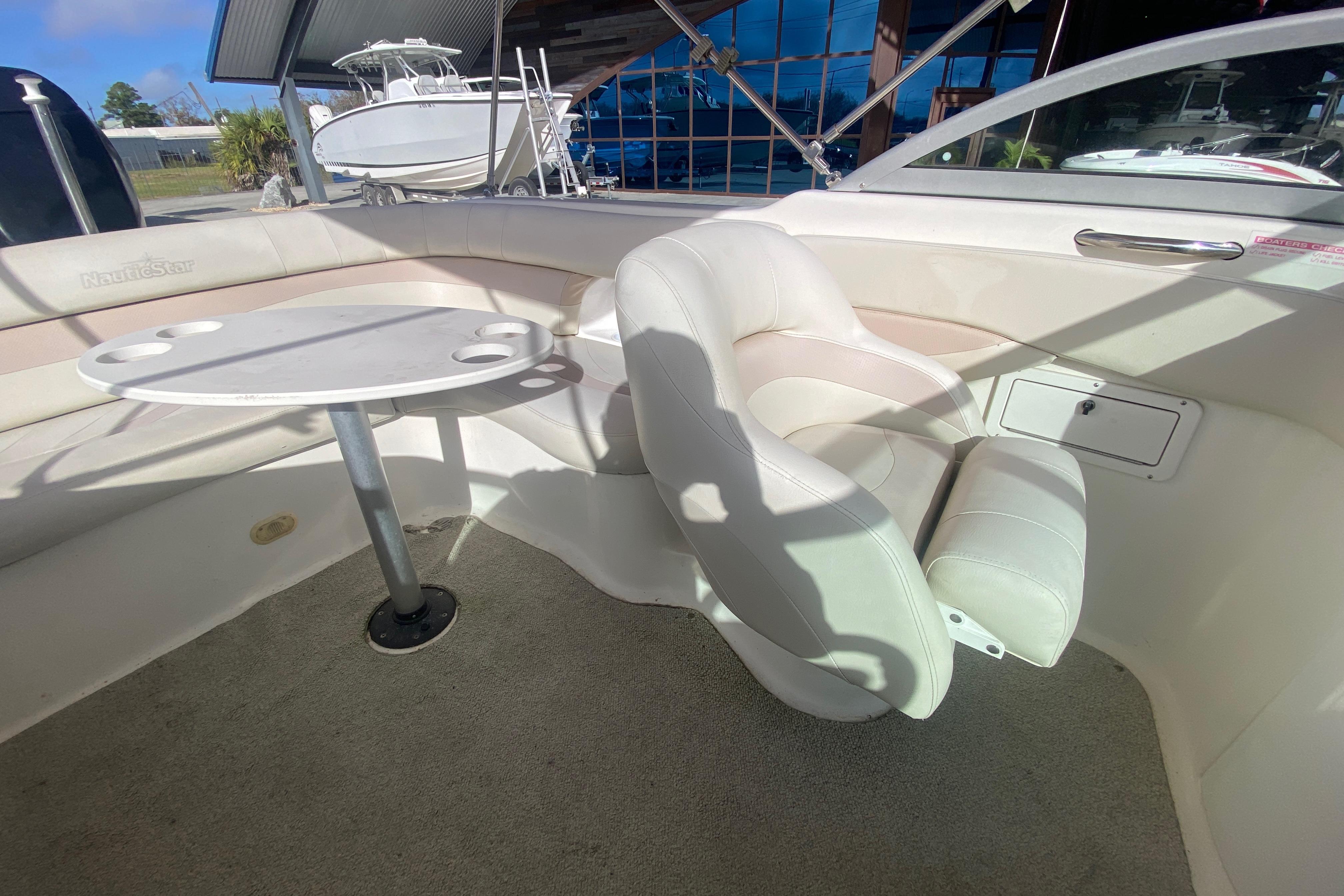 2007 NauticStar 230DC Sport Deck interior with seating and table setup.