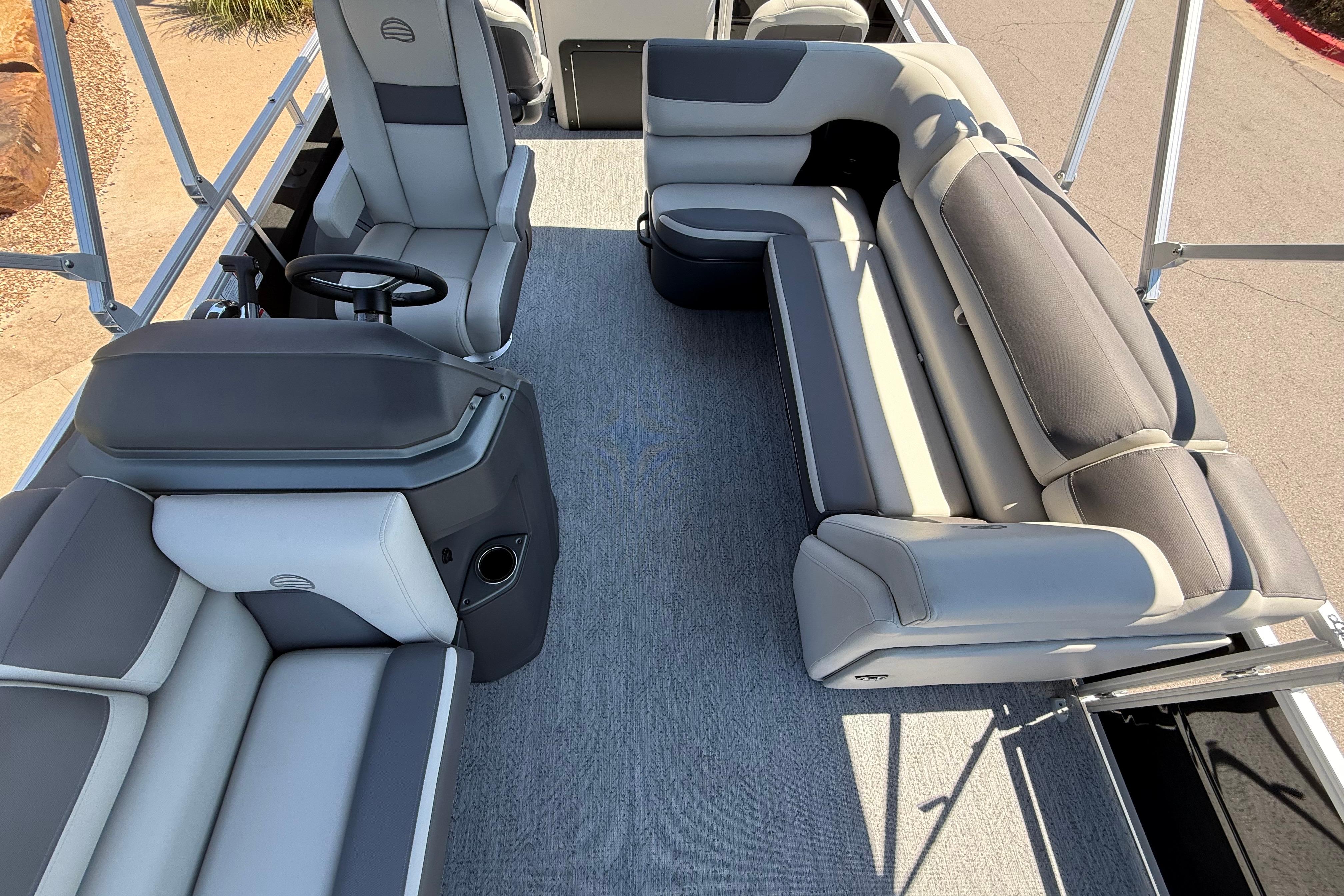 2026 Sun Tracker Fishin' Barge 22 DLX interior with plush seating and steering console.
