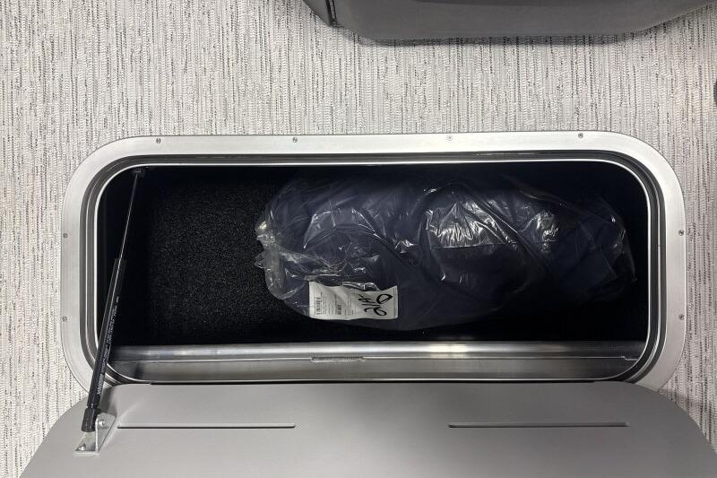 Storage compartment of 2026 Bennington 23 SSRSF boat with packaged item inside.