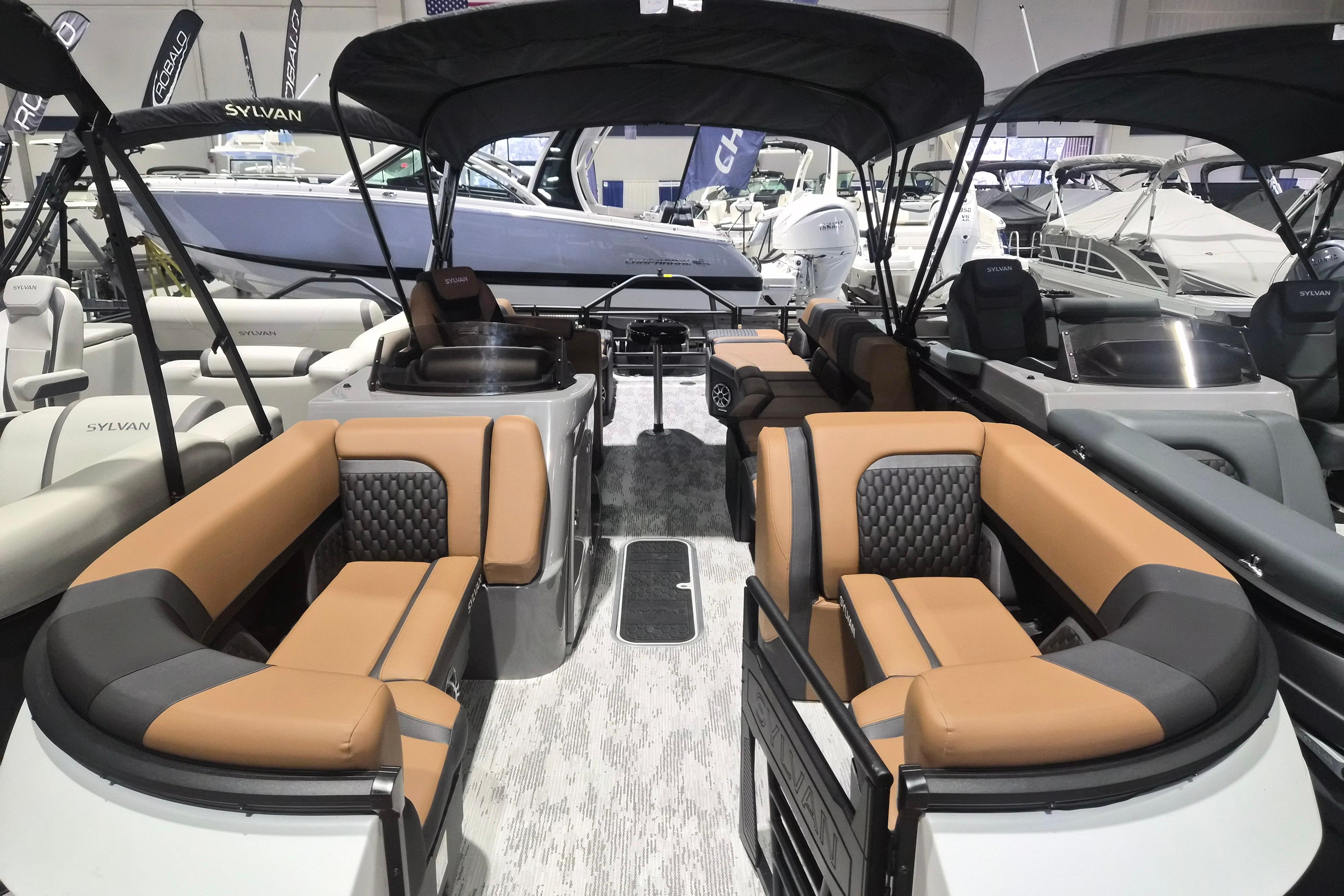 2026 Sylvan L3 SLZ pontoon boat with luxurious seating and canopy at a boat show.