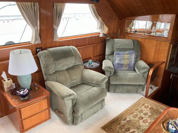 Cozy interior of 2000 Novatec Islander 55 with plush armchairs and wooden accents.