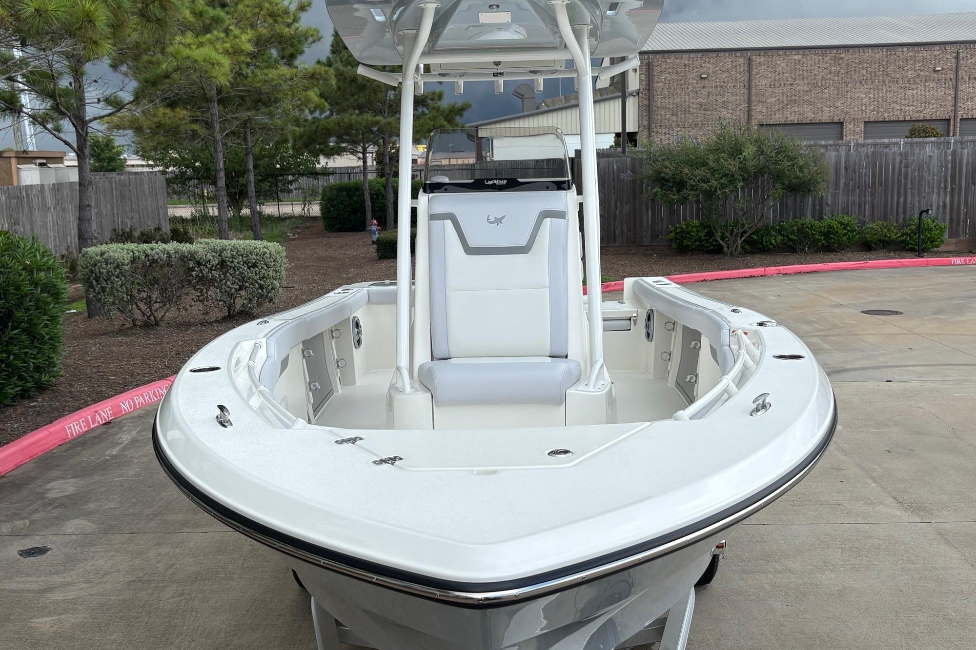 2026 Mako 226 Center Console boat in a parking area, showcasing sleek design and spacious seating.