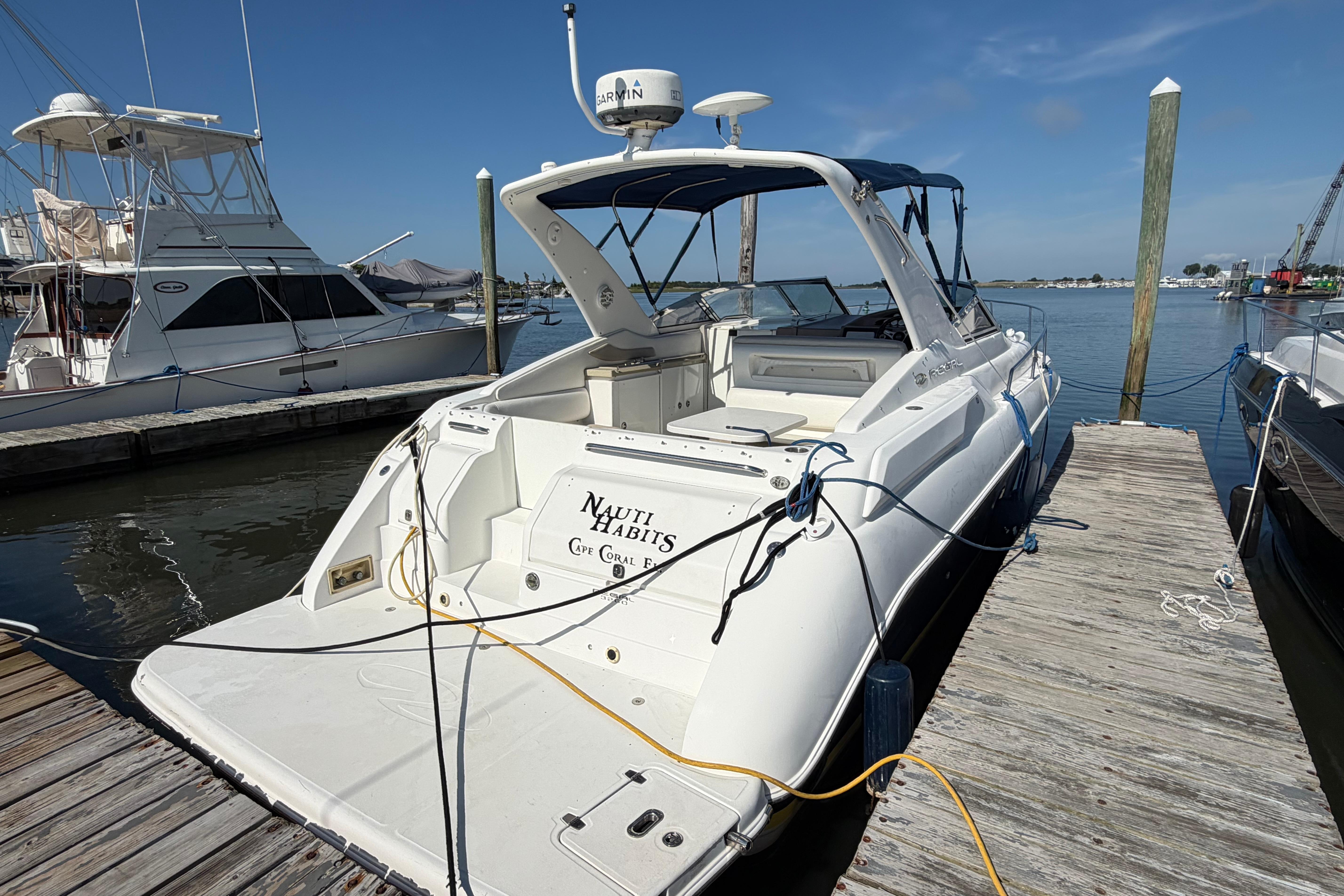 2003 Regal Commodore 3260 yacht docked at marina under clear blue sky.