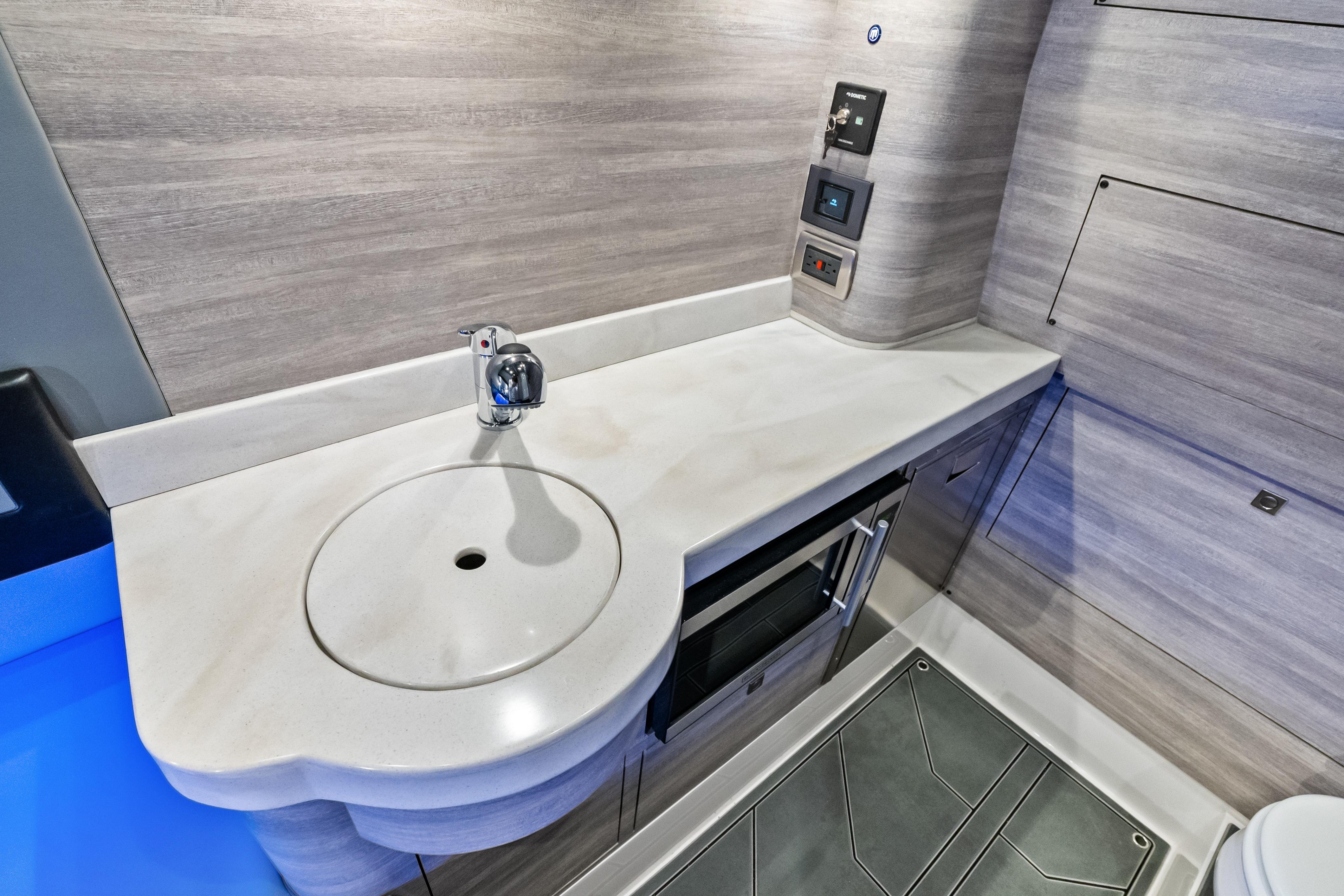 Modern bathroom interior of 2027 Mystic Powerboats M4200 with sleek sink and control panel.