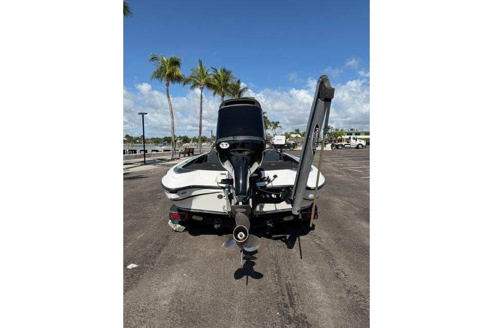 2005 Triton Tr-21X PD boat with outboard motor in sunny parking lot.