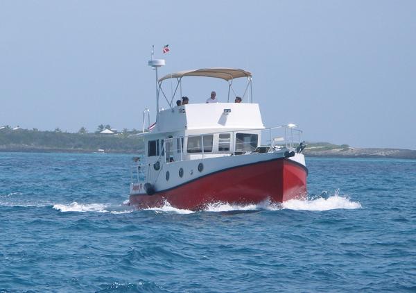 2025 Great Harbour N40 boat cruising on open water with a red hull.