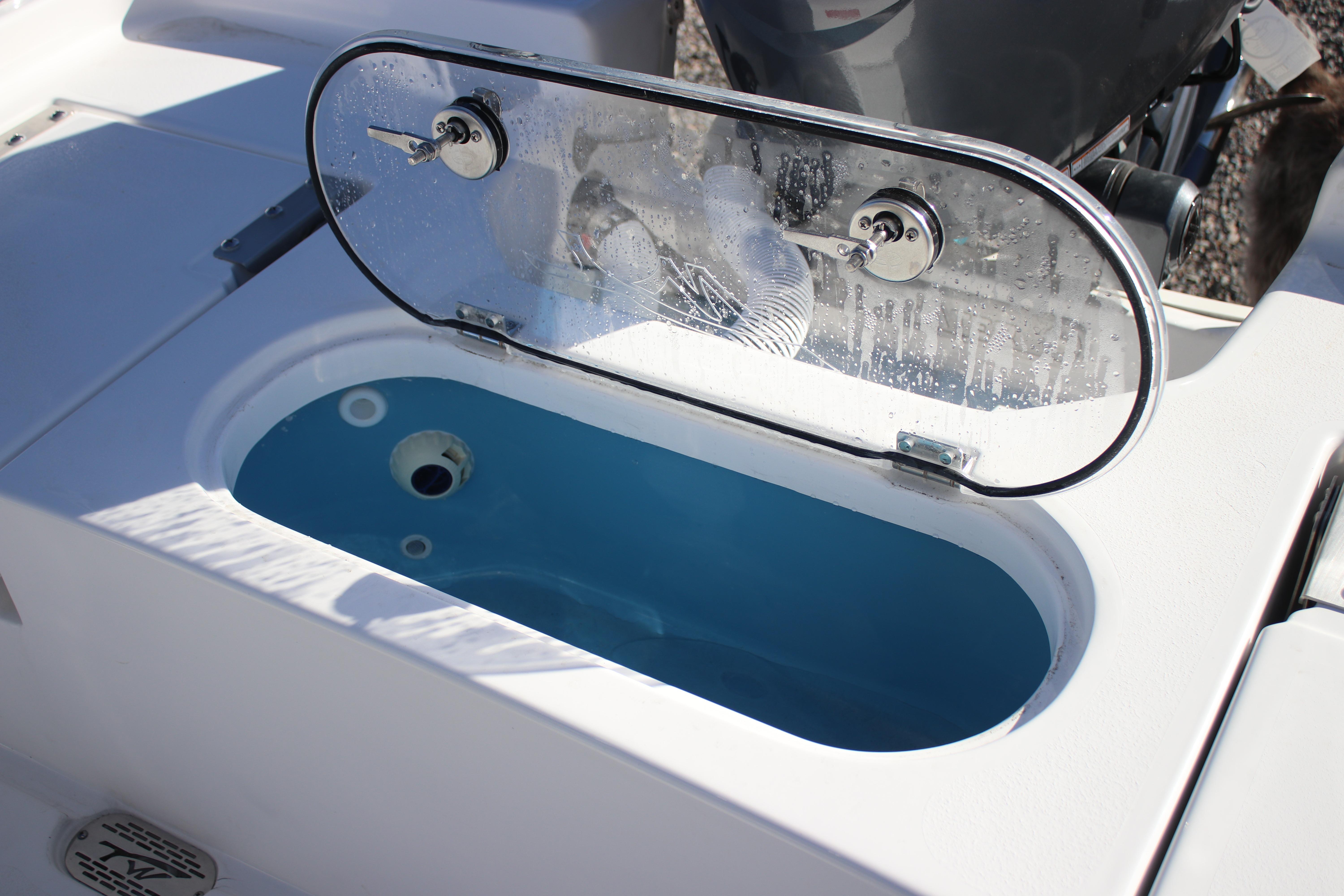 Livewell on 2026 Tidewater 2210 Carolina Bay boat, featuring a clear lid and blue interior.